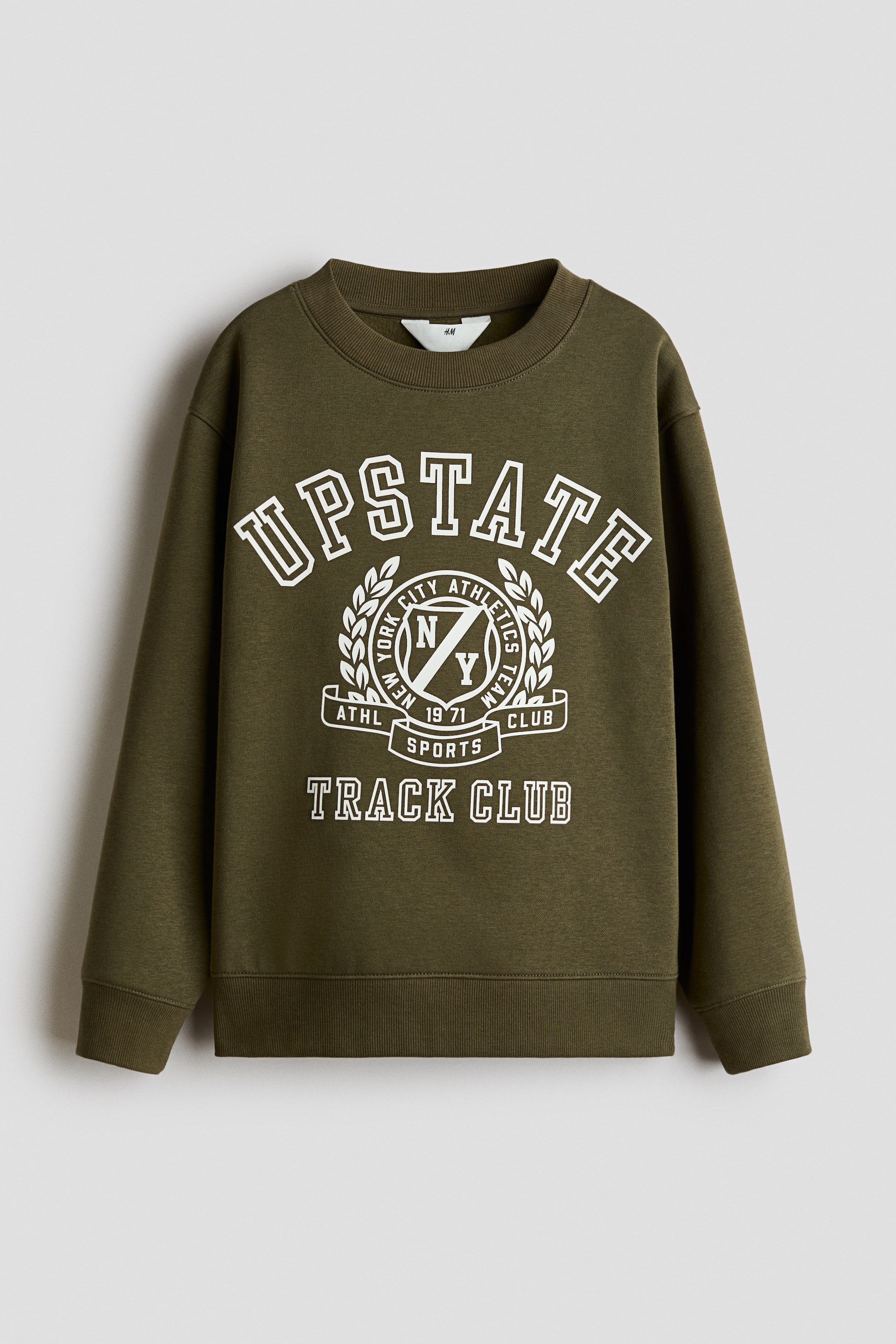 View larger image: An olive green sweatshirt is shown from the front, featuring a white collegiate-style graphic print on the chest with the text "UPSTATE" and "TRACK CLUB" surrounding a central athletic emblem. The sweatshirt is designed with a ribbed crew neckline, dropped shoulders, long sleeves with ribbed cuffs, and a ribbed hem.
