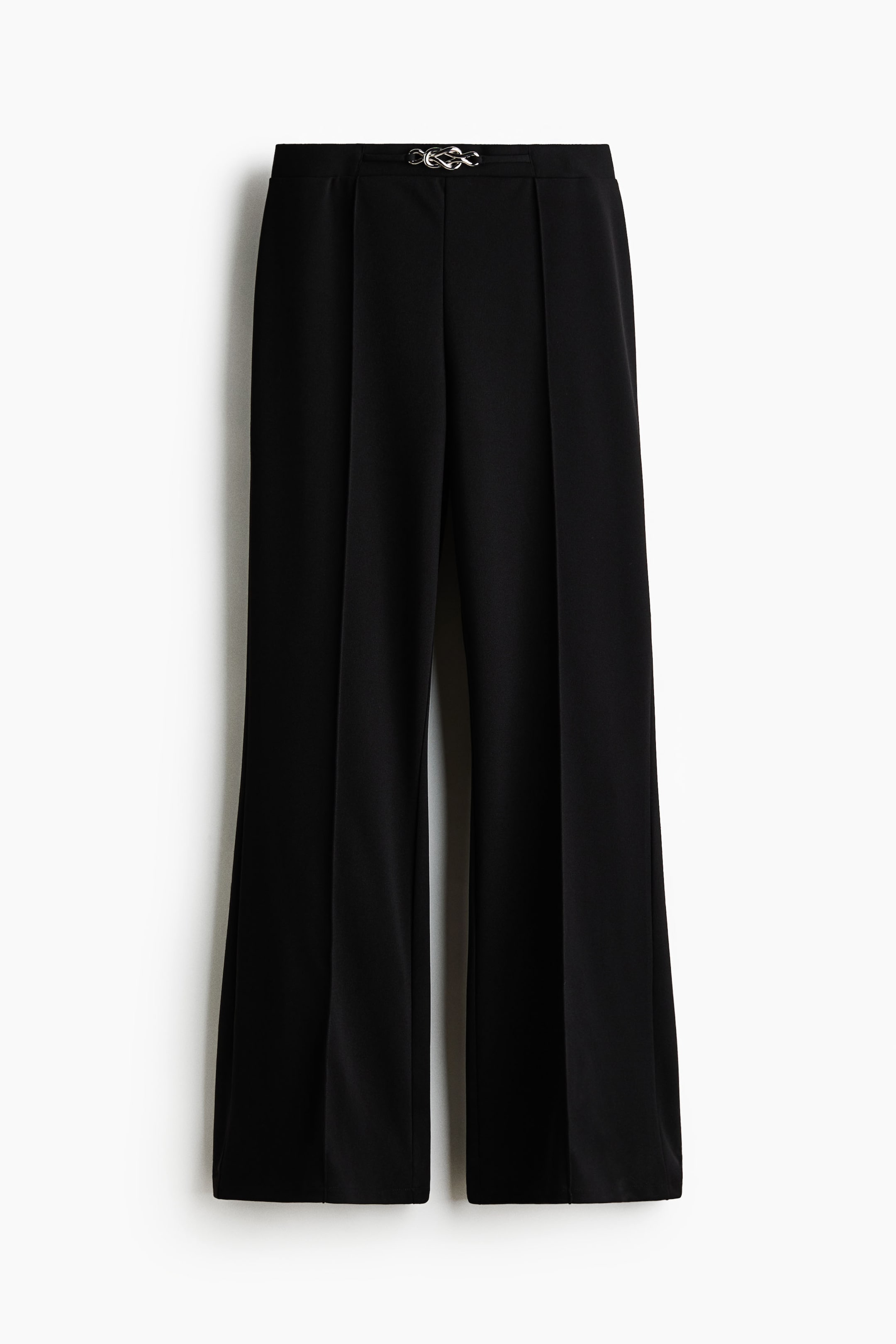 View larger image: The black trousers are showcased from the front, highlighting a silver-toned interlocking hardware detail at the centre waistband. They are crafted with front pleats and a wide-leg silhouette, featuring vertical creases down each leg.