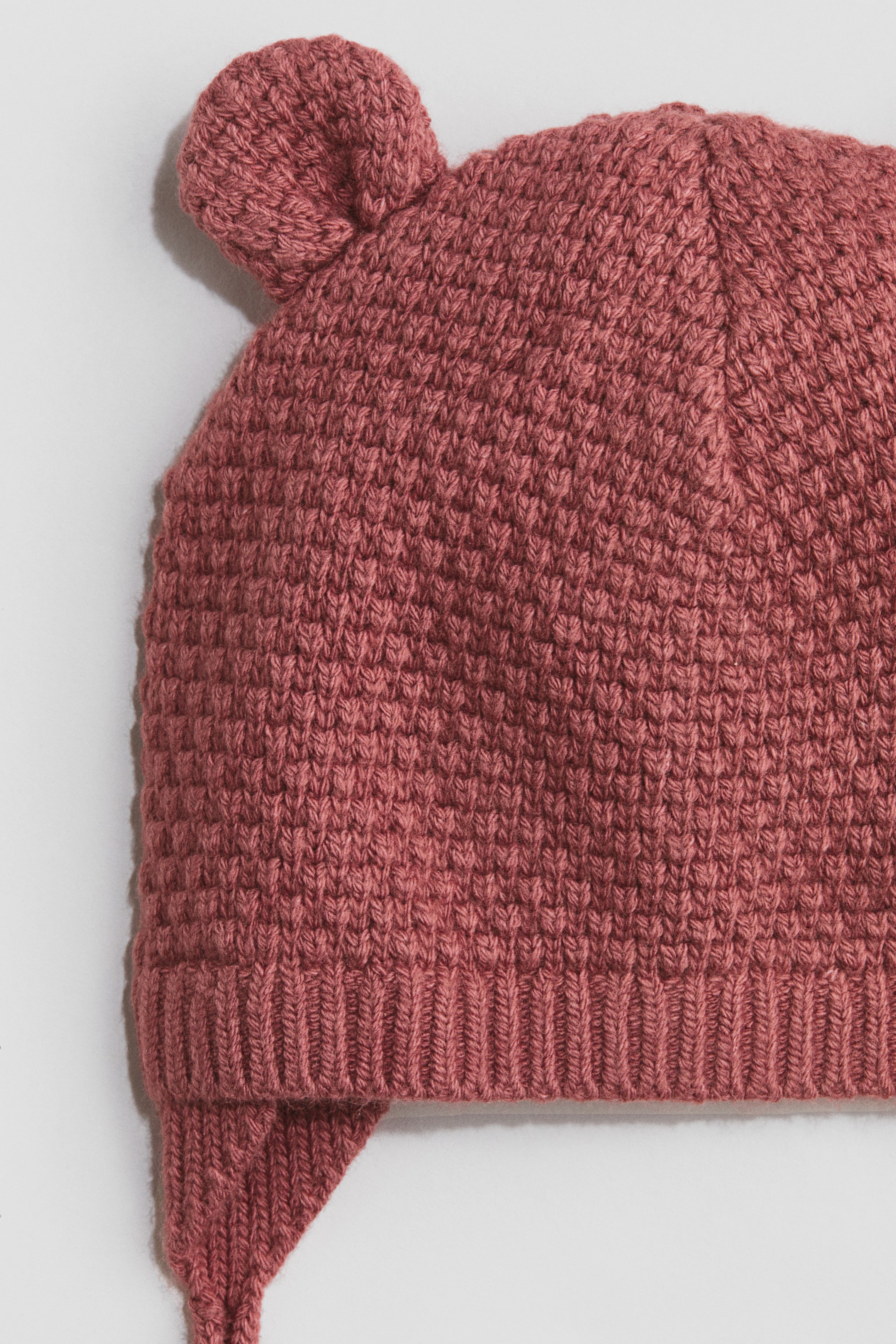 Tuque en tricot avec liens à nouer sous le menton