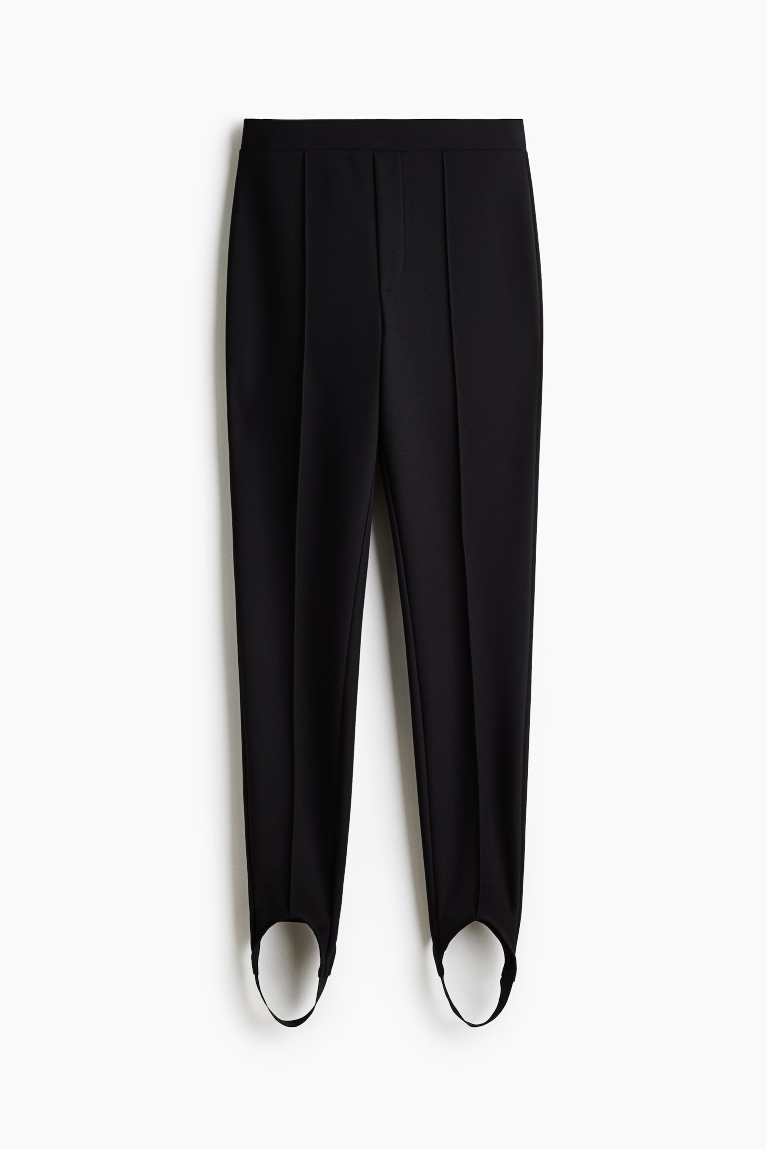 Dieses Paar schwarzer Stegleggings ist von vorne zu sehen und verfÃ¼gt Ã¼ber einen hoch geschnittenen Bund mit einer sauberen, glatten Vorderseite. Die schmal zulaufenden, schmalen Beine zeigen markante vertikale SteppnÃ¤hte entlang der Mitte und enden an den BÃ¼ndchen in geschwungenen Stegriemen. - 1