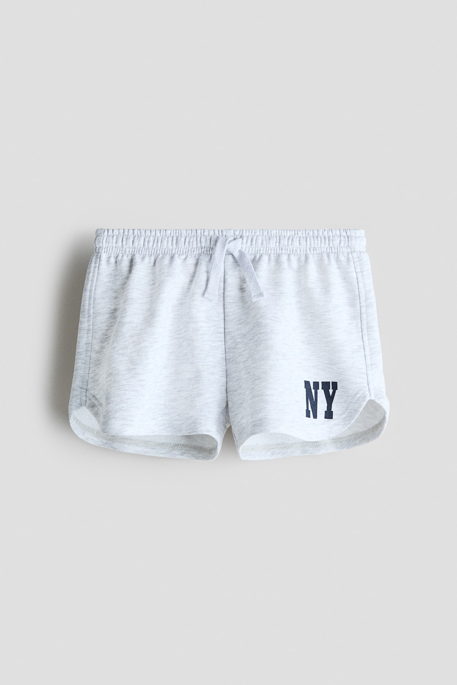 Má»t chiáº¿c quáº§n short ná» mÃ u xÃ¡m nháº¡t vÃ¢n muá»i tiÃªu Äang ÄÆ°á»£c chá»¥p chÃ­nh diá»n, ná»i báº­t vá»i cáº¡p chun cÃ³ dÃ¢y rÃºt Äá»ng mÃ u tháº¯t á» giá»¯a. Quáº§n short cÃ³ ÄÆ°á»ng lai hai bÃªn cong vÃ  há»a tiáº¿t chá»¯ khá»i "NY" mÃ u xanh navy á» pháº§n á»ng trÃ¡i phÃ­a dÆ°á»i.