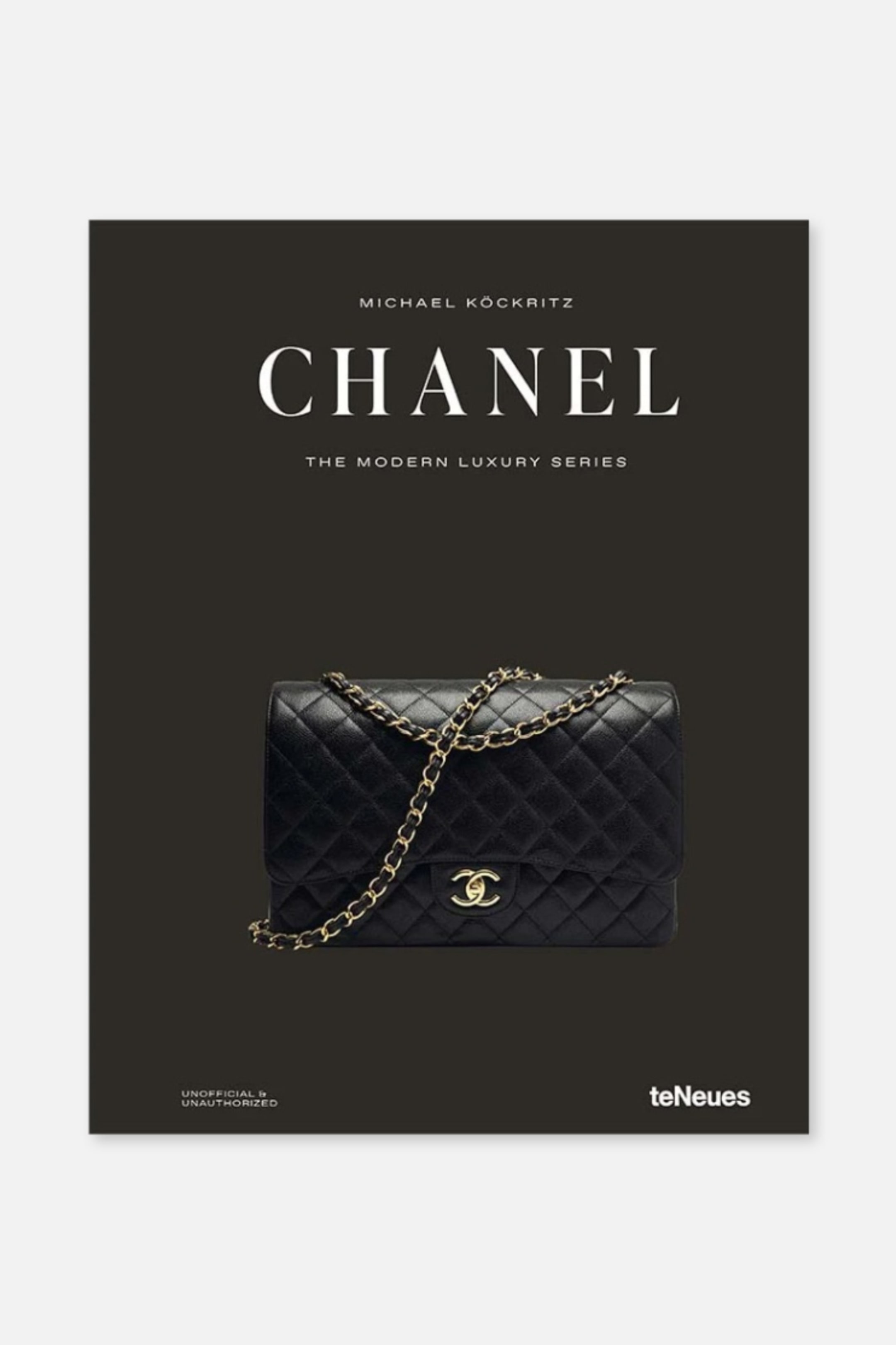 Se større billede: En bog præsenterer sin sorte forside, vendt fremad, med titlen 'CHANEL' i store hvide bogstaver. Forsiden viser en sort quiltet håndtaske med en guldkæde og et gyldent sammenflettet C-logo, sammen med teksten der identificerer 'MICHAEL KÜCKRITZ', 'THE MODERN LUXURY SERIES', 'UNOFFICIAL & UNAUTHORIZED', og 'teNeues'.