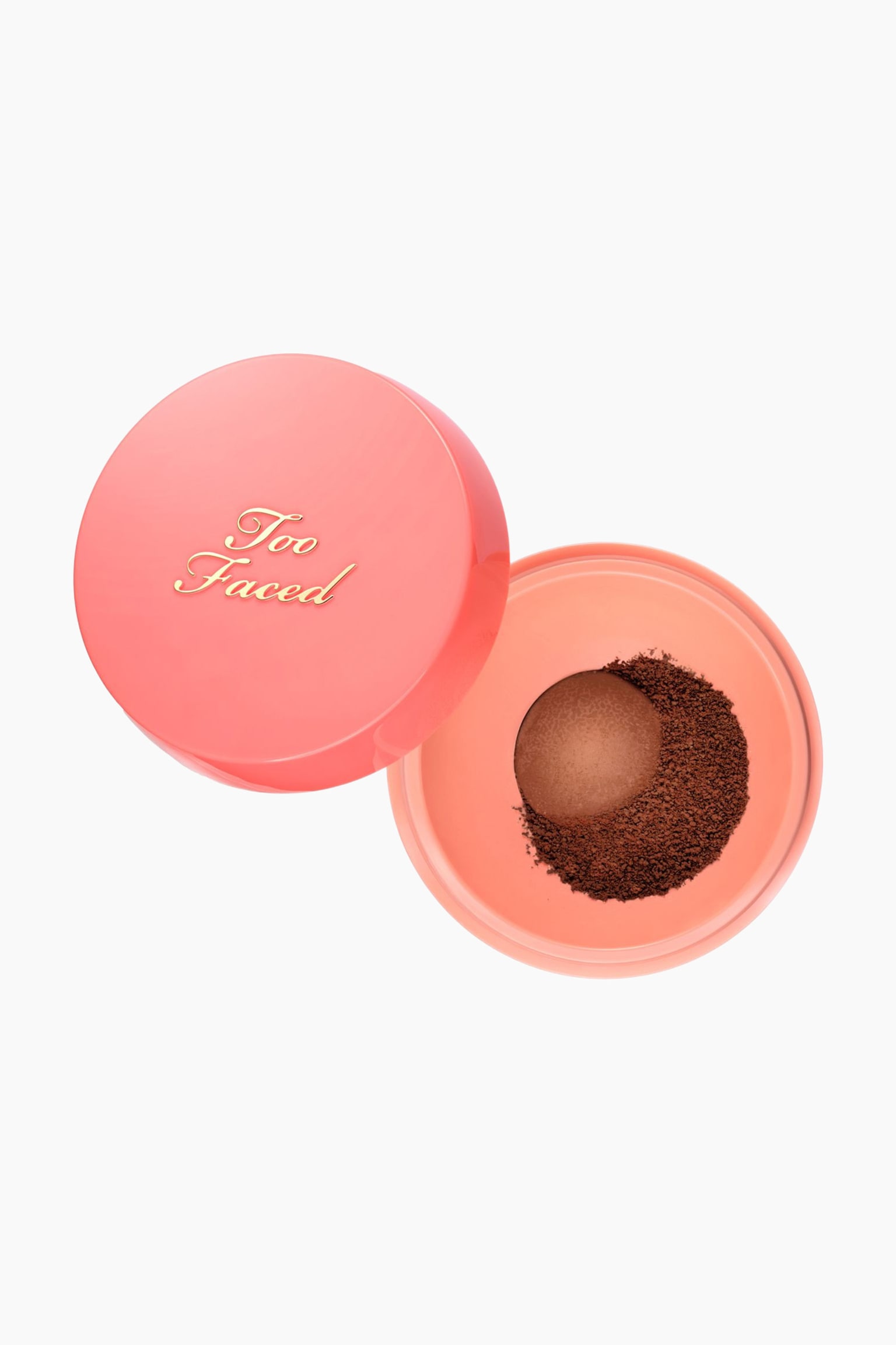 Peach Perfector Blurring Loose Setting Powder visas i en vy uppifrÃ¥n, dÃ¤r en Ã¶ppen rund persikorosa behÃ¥llare stÃ¥r bredvid sitt glansiga persikofÃ¤rgade lock med guldfÃ¤rgad "Too Faced"-branding. En cirkulÃ¤r mesh-doserare inuti behÃ¥llaren hÃ¥ller en kupol av djupt brunt puder, med lÃ¶sa granuler utspridda runt omkring.