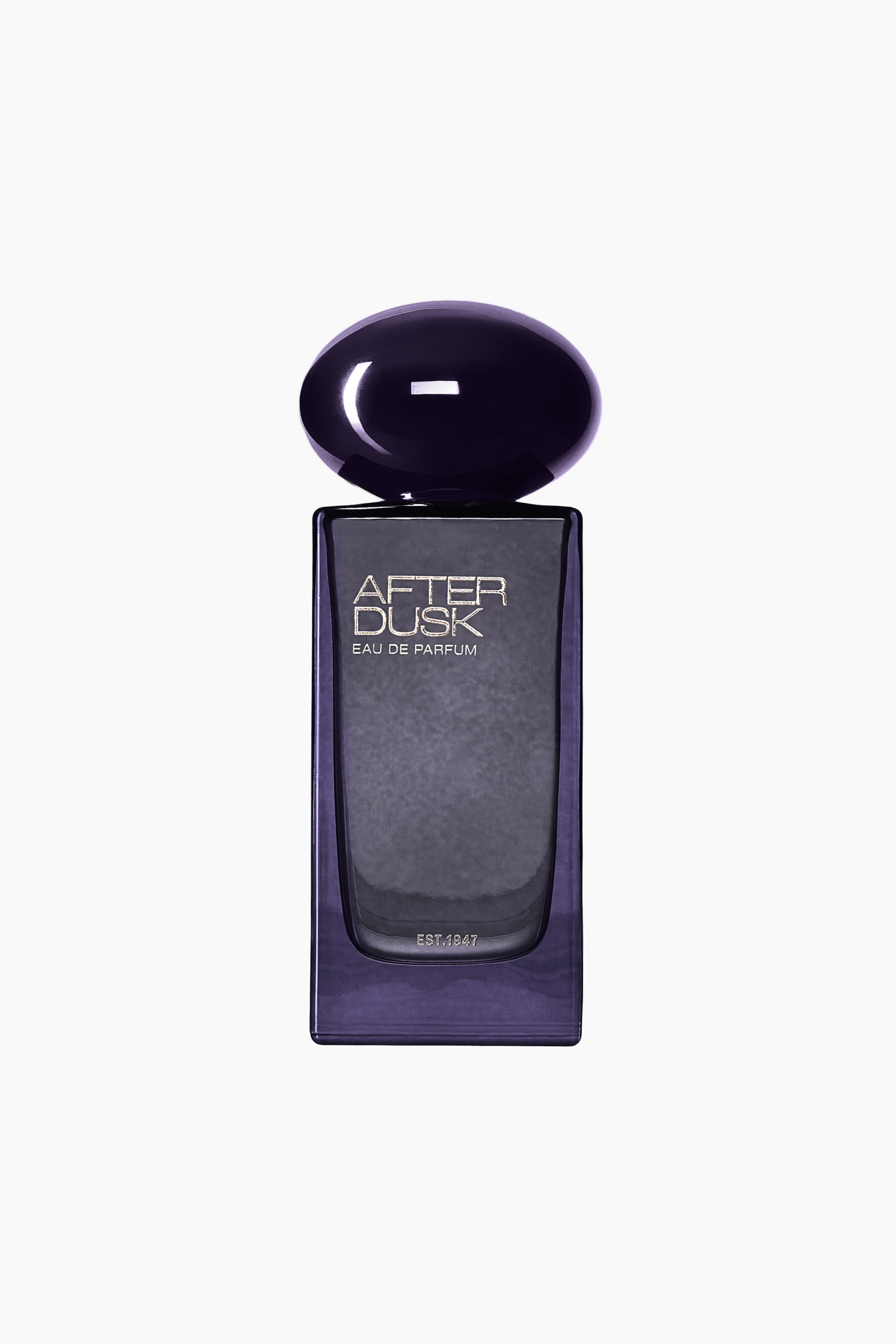 View larger image: A front view of the "After Dusk" Eau de Parfum bottle, featuring a rectangular dark purple glass body with a textured, deep grey front panel. The bottle is topped with a glossy, rounded, pebble-shaped cap in deep purple and displays silver lettering reading "AFTER DUSK EAU DE PARFUM" and "EST. 1947".