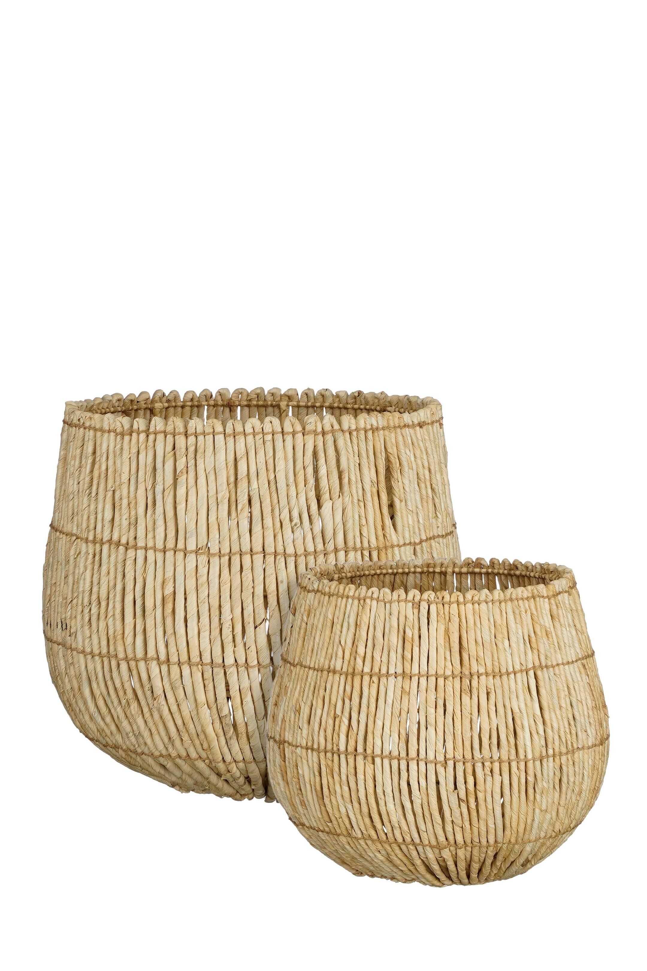 Agrandir l'image: Deux paniers en fibres naturelles tressées sont exposés, le plus grand panier étant placé derrière et légèrement à gauche du plus petit. Les deux paniers présentent une forme arrondie, semblable à un bol, où des brins vert clair sont liés ensemble par un tissage horizontal.