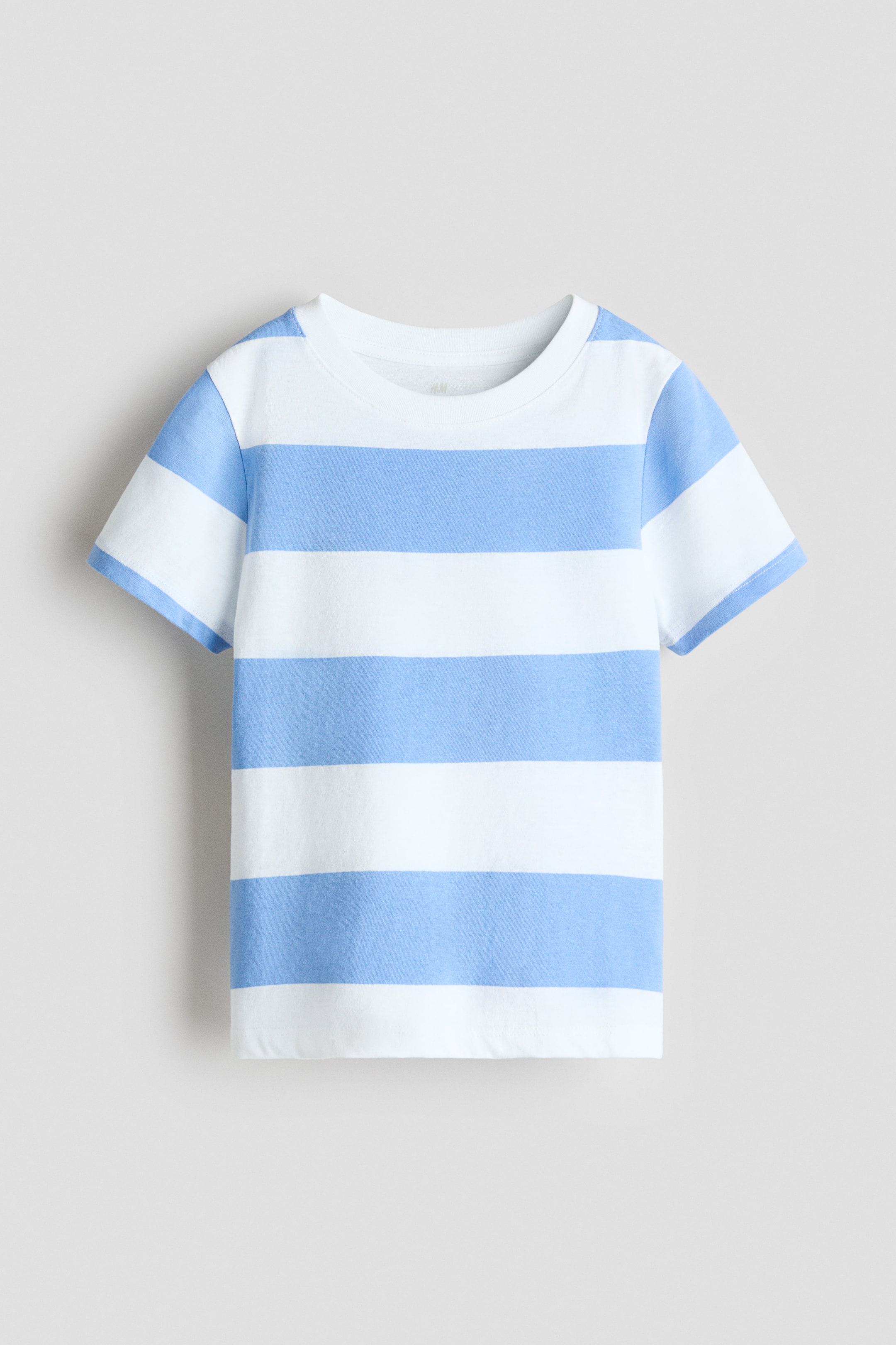 Visualizza l'immagine ingrandita: Una T-shirt in morbido jersey di cotone presenta la parte anteriore, caratterizzata da strisce orizzontali bianche e azzurro chiaro alternate. È progettata con un collo rotondo e maniche corte.