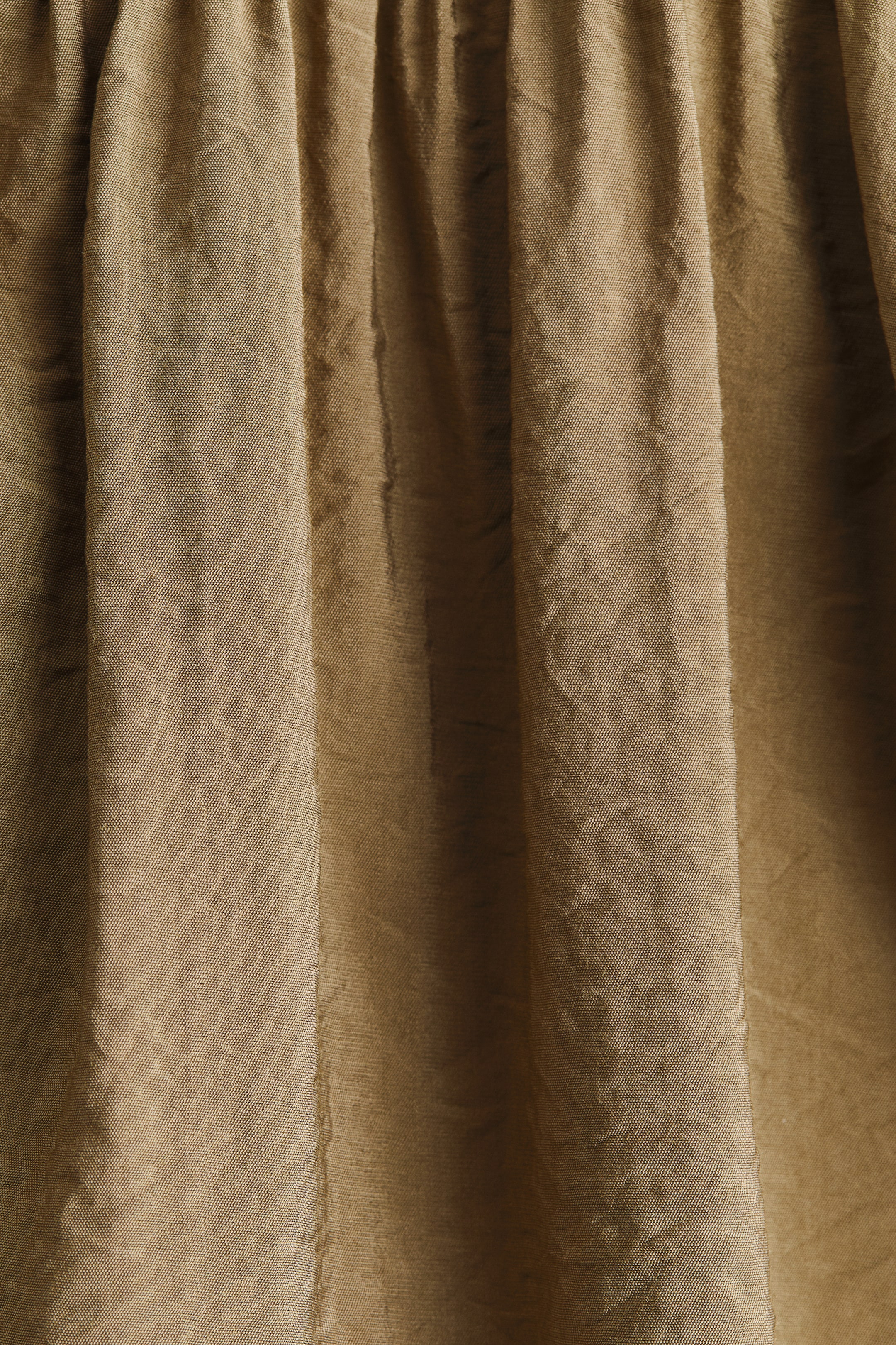Agrandir l'image: Le tissu de la jupe de la robe présente un tissage texturé et froncé en mélange de viscose, dans une teinte olive atténuée, affichant des plis verticaux prononcés.