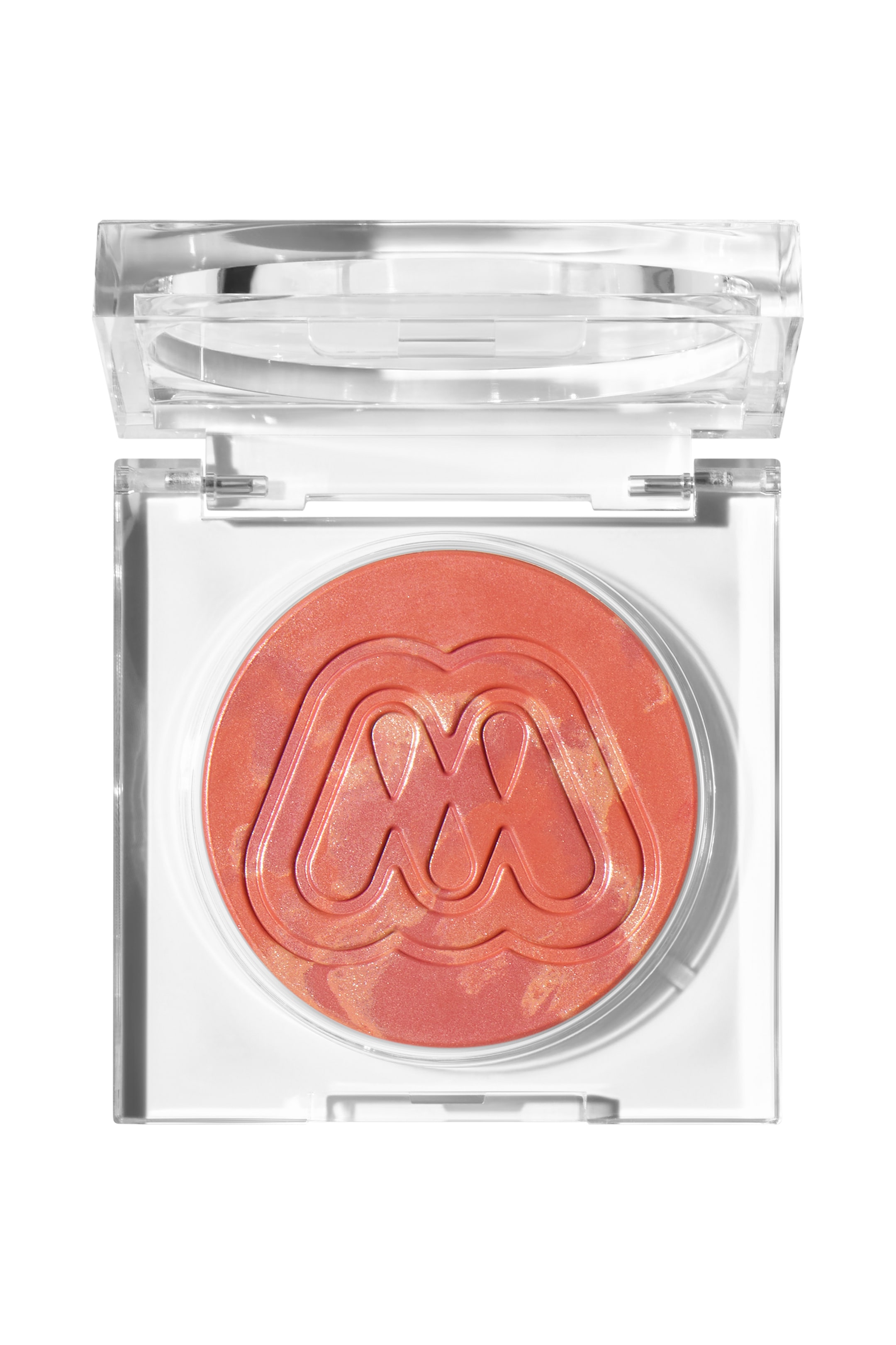 Se større billede: En gennemsigtig firkantet makeup-kompakt viser et åbent gennemsigtigt låg og en cirkulær pande med skinnende koral-orange makeup med gyldne highlights. Makeuppen har et fremtrædende præget stiliseret "M"-logo i midten.