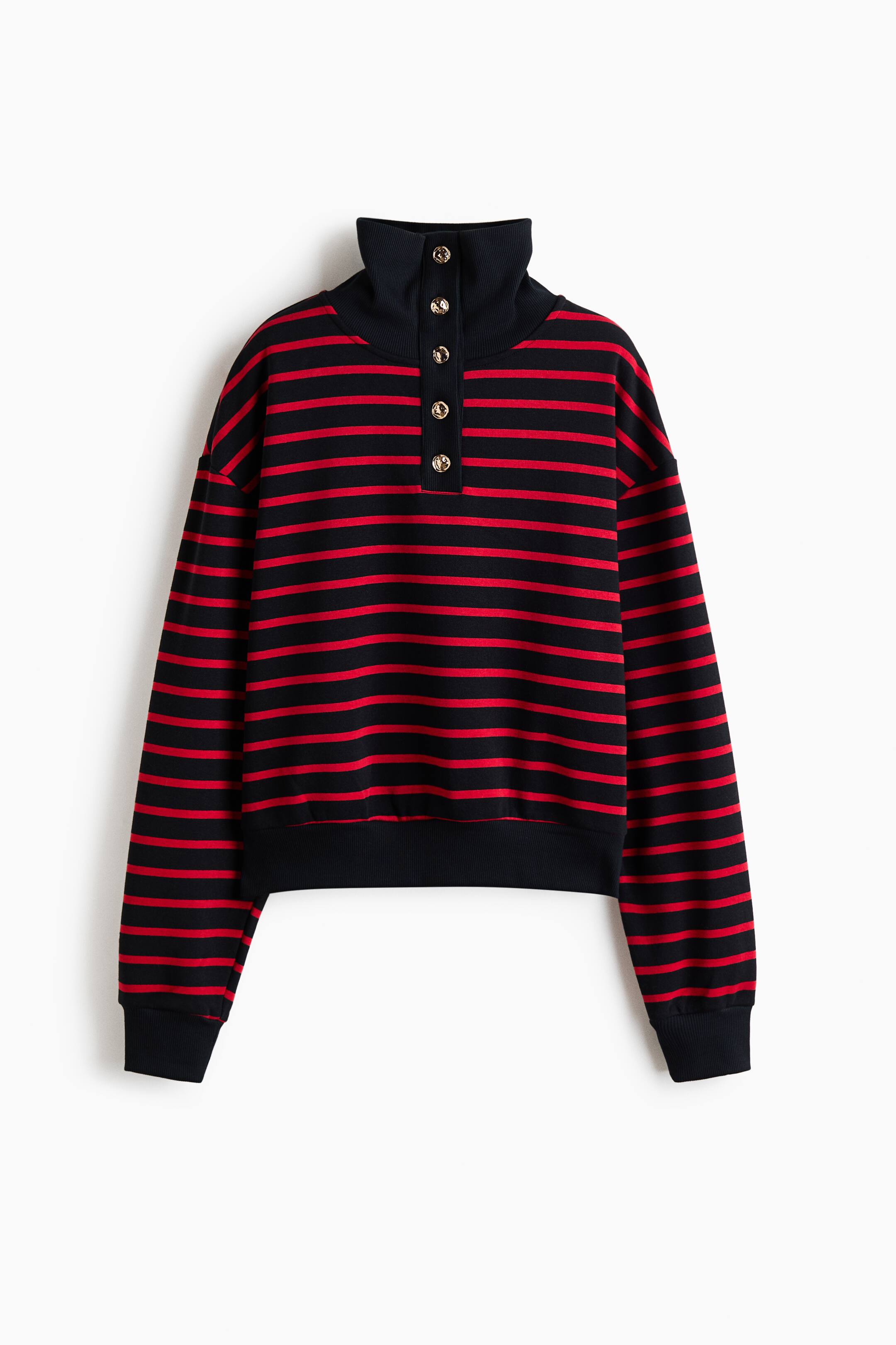 View larger image: A loose-fit, red and black horizontally striped sweatshirt is hanging facing the front, displaying a high ribbed stand collar with a five-button placket. The top features dropped shoulders, long sleeves, and solid black ribbed trim at the cuffs and hem.