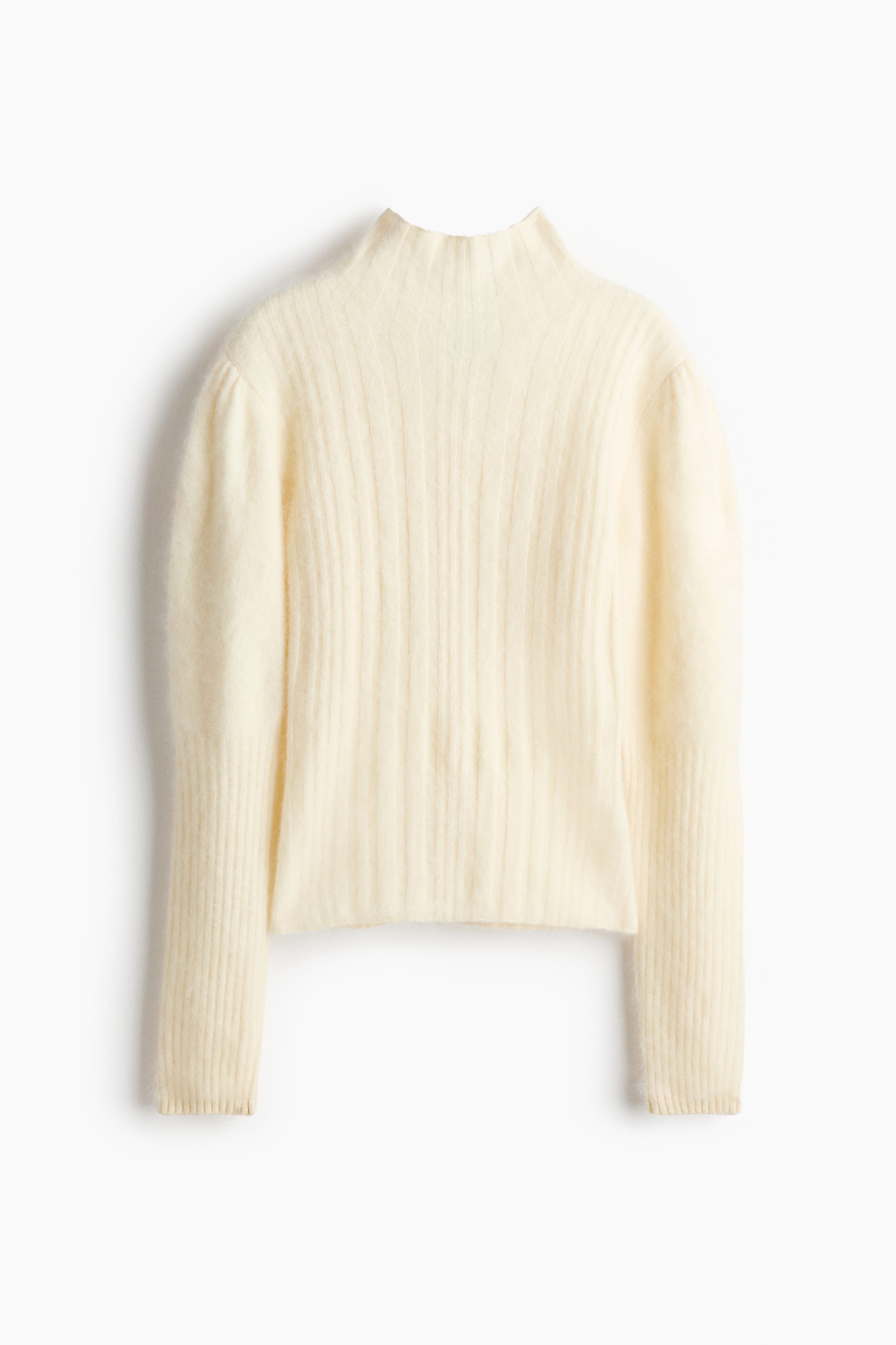 Un pull crÃ¨me ajustÃ© en laine tricotÃ©e cÃ´telÃ©e, dotÃ© dâun col montant et de manches bouffantes spectaculaires avec de longs poignets cÃ´telÃ©s, est portÃ© par le mannequin. Le pull est superposÃ© sous un corset crÃ¨me structurÃ© assorti et stylÃ© avec un pantalon noir.