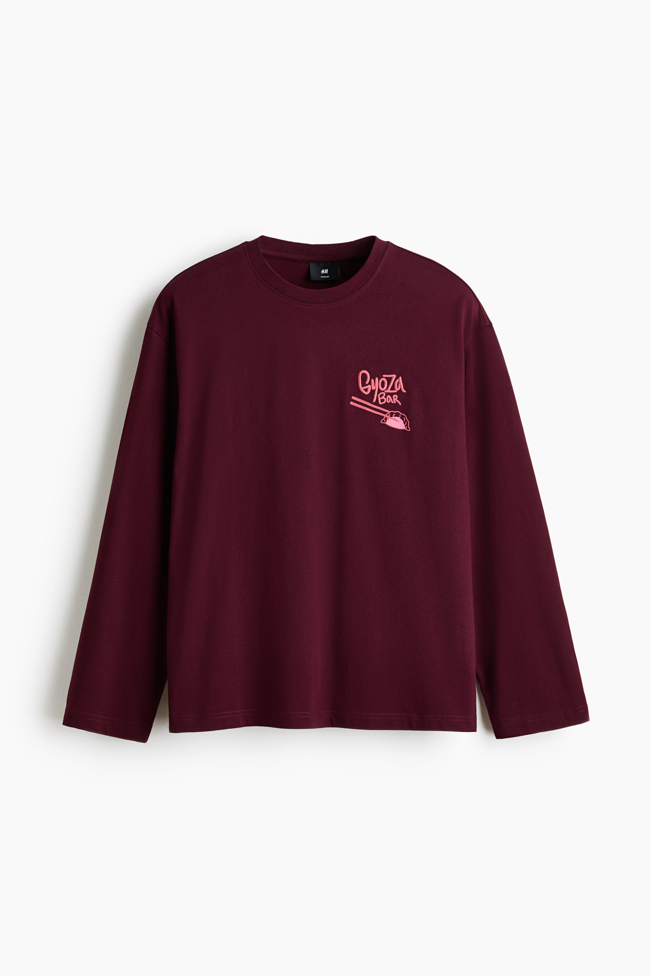 View larger image: Presenting a maroon long-sleeved T-shirt from the front view, showcasing a regular fit, a round, rib-trimmed neckline, dropped shoulders, and a straight-cut hem. A pink graphic print with the words "Gyoza BAR" along with chopsticks and a dumpling is featured on the left chest.