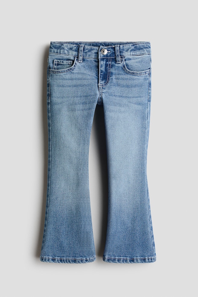 Ein Paar blau gewaschene Schlagjeans ist von vorne zu sehen und zeigt ein klassisches Five-Pocket-Design mit Metallknopfverschluss und GÃ¼rtelschlaufen am Bund. Die Jeans weist dezente Auswaschungen an den Oberschenkeln auf und weitet sich vom Knie bis zum Saum zu einem Schlag aus. - 1