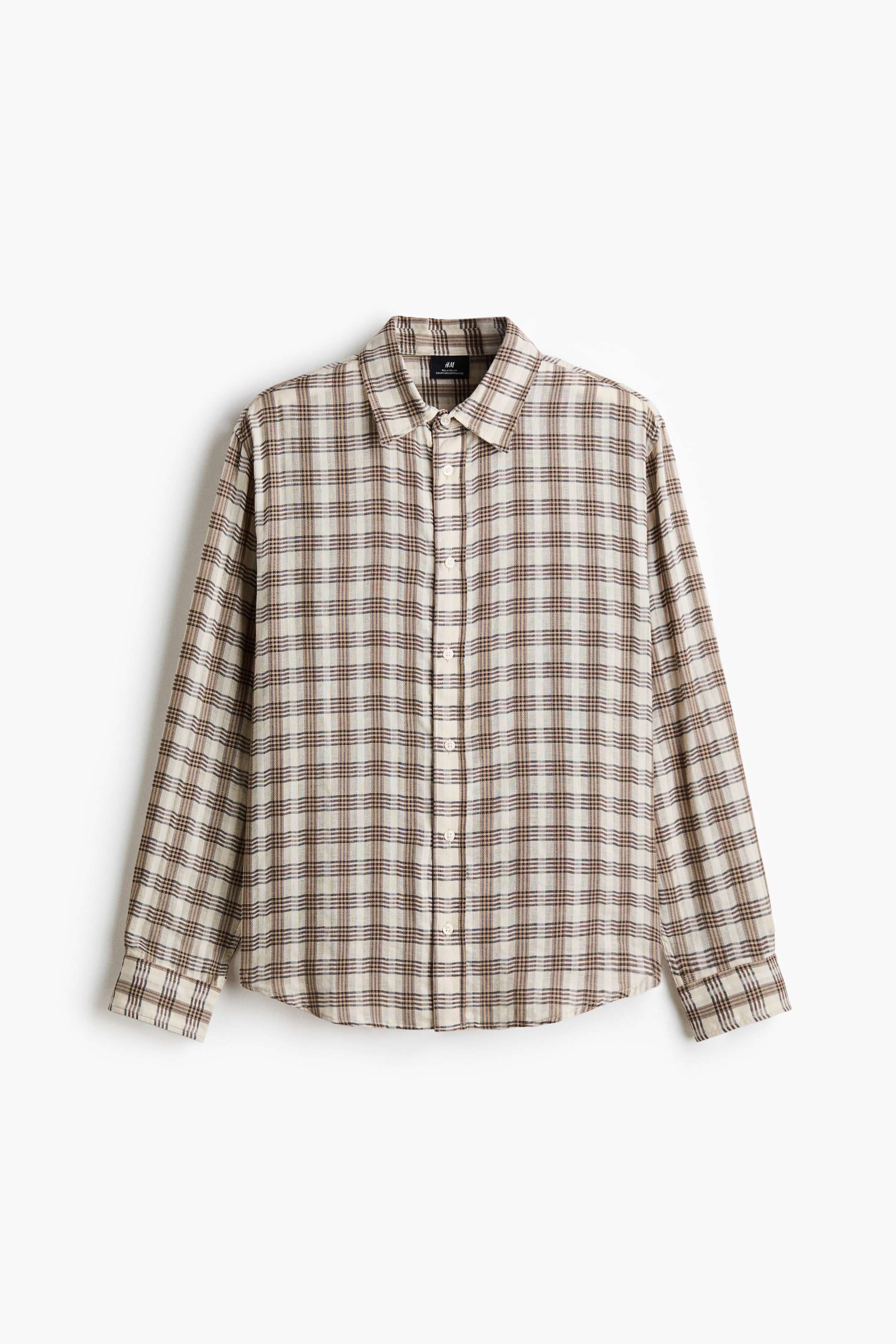 查看大圖: 一件格子襯衫展示其正面視圖，以米白色為底，配以交錯的棕色和褐色線條形成方格圖案。它設計有標準領口、長袖配有鈕扣袖口，還有一個全鈕扣前襟設計，鈕扣為淺色。