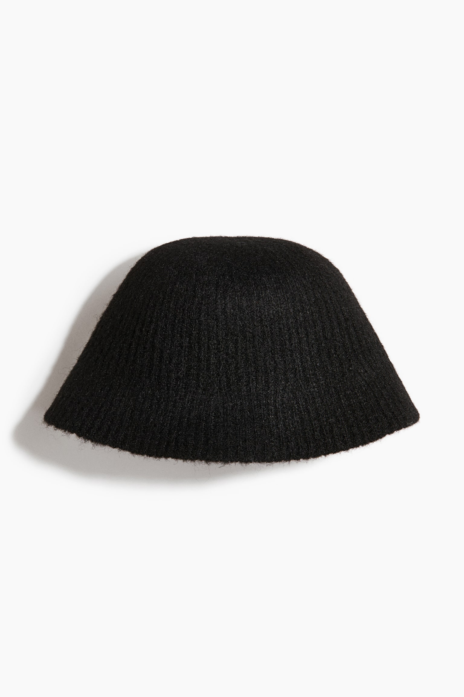 Un bob en maille noire avec une finition texturÃ©e et duveteuse est prÃ©sentÃ© de face. Le chapeau affiche une calotte arrondie en forme de cloche, avec un bord inclinÃ© et une structure en maille cÃ´telÃ©e fine sur lâensemble.