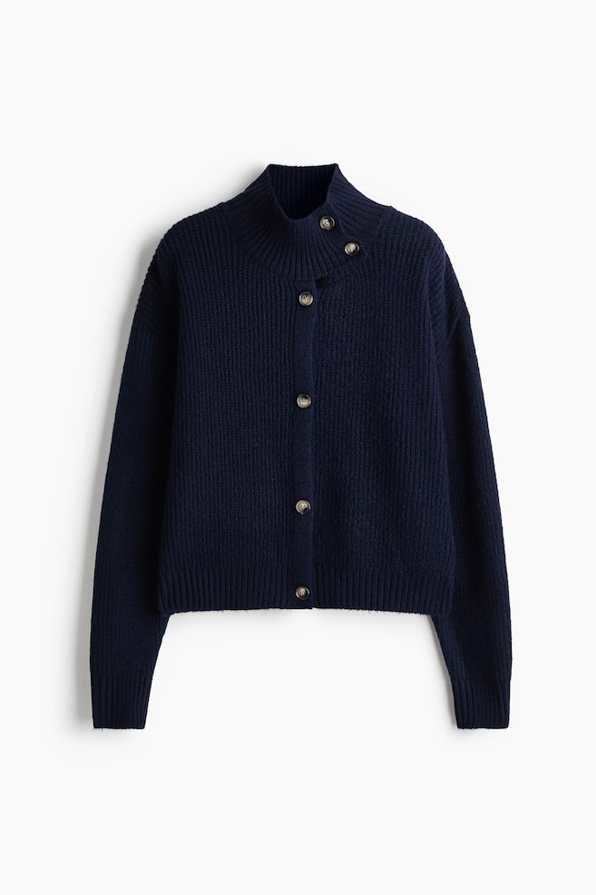 Eine marineblaue Cardigan-Jacke aus Rippstrick ist von vorne zu sehen und verfÃ¼gt Ã¼ber einen durchgehenden Knopfverschluss vorne sowie einen hohen Trichterausschnitt mit zwei KnopfverschlÃ¼ssen. Das KleidungsstÃ¼ck zeigt Ã¼berschnittene Schultern, lange Ãrmel mit gerippten BÃ¼ndchen und einen geraden, gerippten Saum. - 1