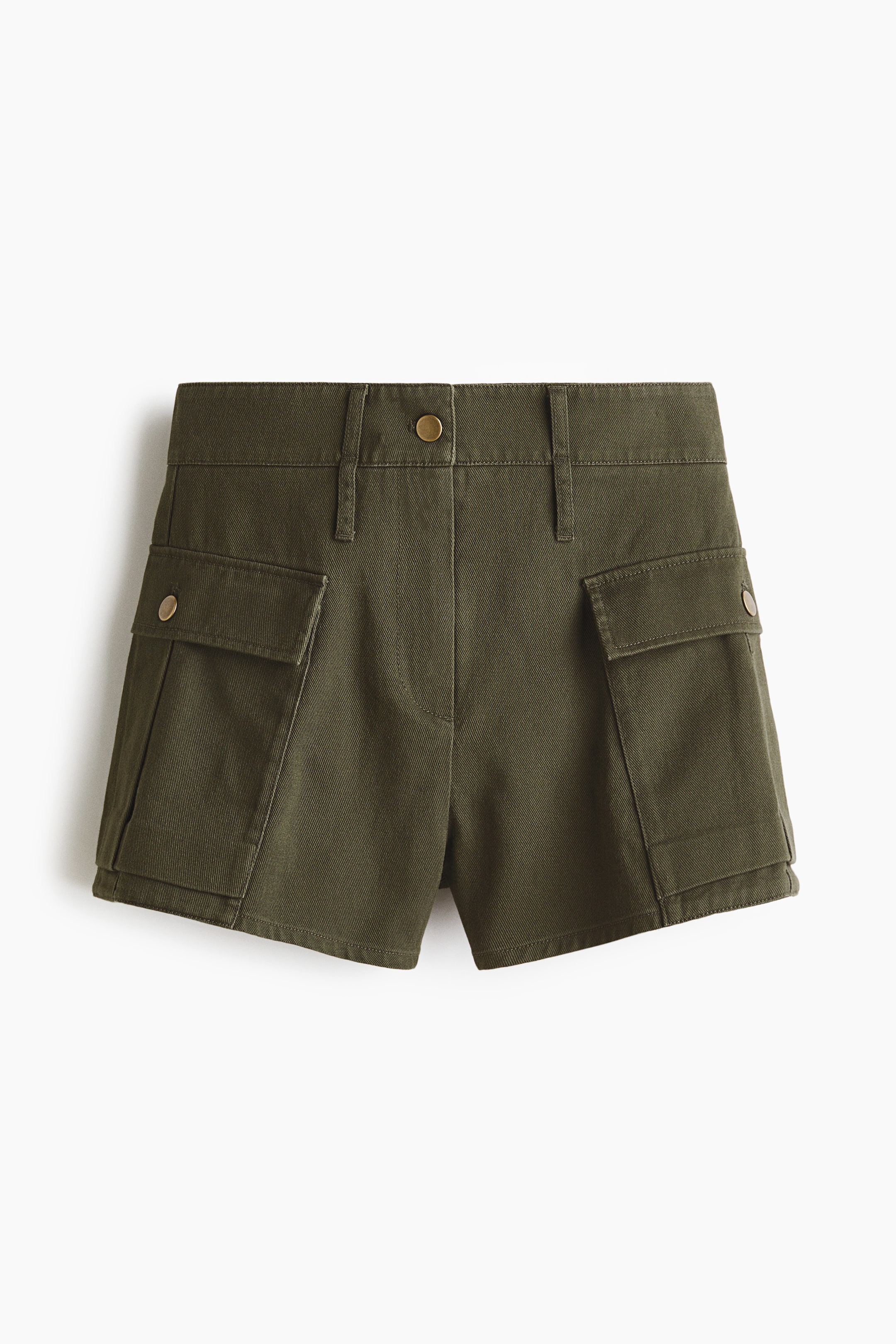 Ver imagen más grande: Los pantalones cortos verde oliva se presentan con una vista frontal, con una cintura plana con trabillas para cinturón y un cierre de un solo botón de bronce. Dos grandes bolsillos cargo, cada uno asegurado por una solapa y un pequeño botón de bronce, son visibles en la parte frontal de las piernas.