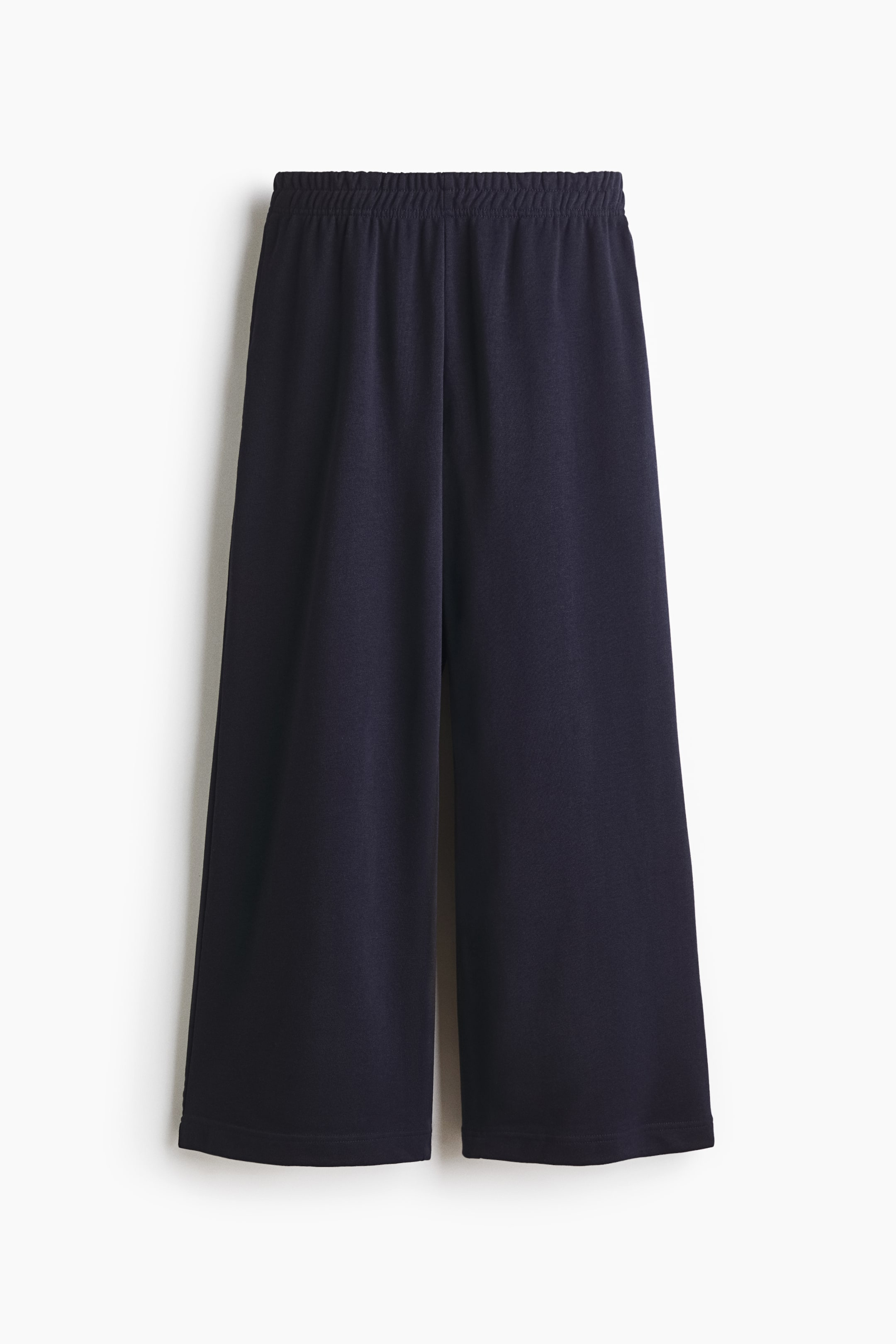 查看大圖: 褲子展示正面視圖，展示深藍色的運動衫面料。它們採用寬鬆版型，具有抽繩鬆緊腰帶和直筒褲腿。