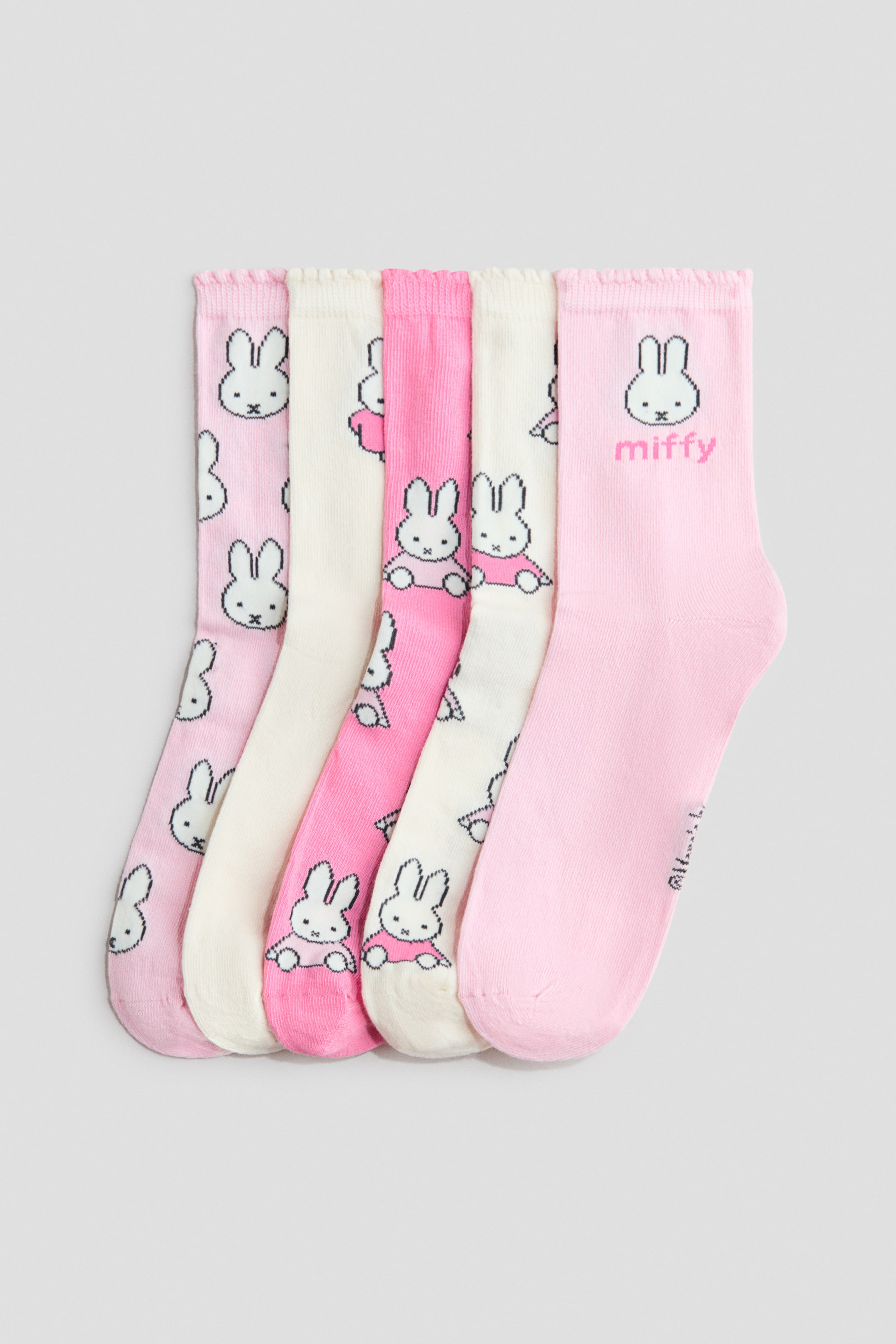 Visualizza immagine più grande: Cinque paia di calzini in maglia fine mostrano i loro frontali, caratterizzati da motivi con il coniglietto Miffy in diverse sfumature di rosa e bianco sporco. Ogni calzino è progettato con bordi elasticizzati e arricciati.