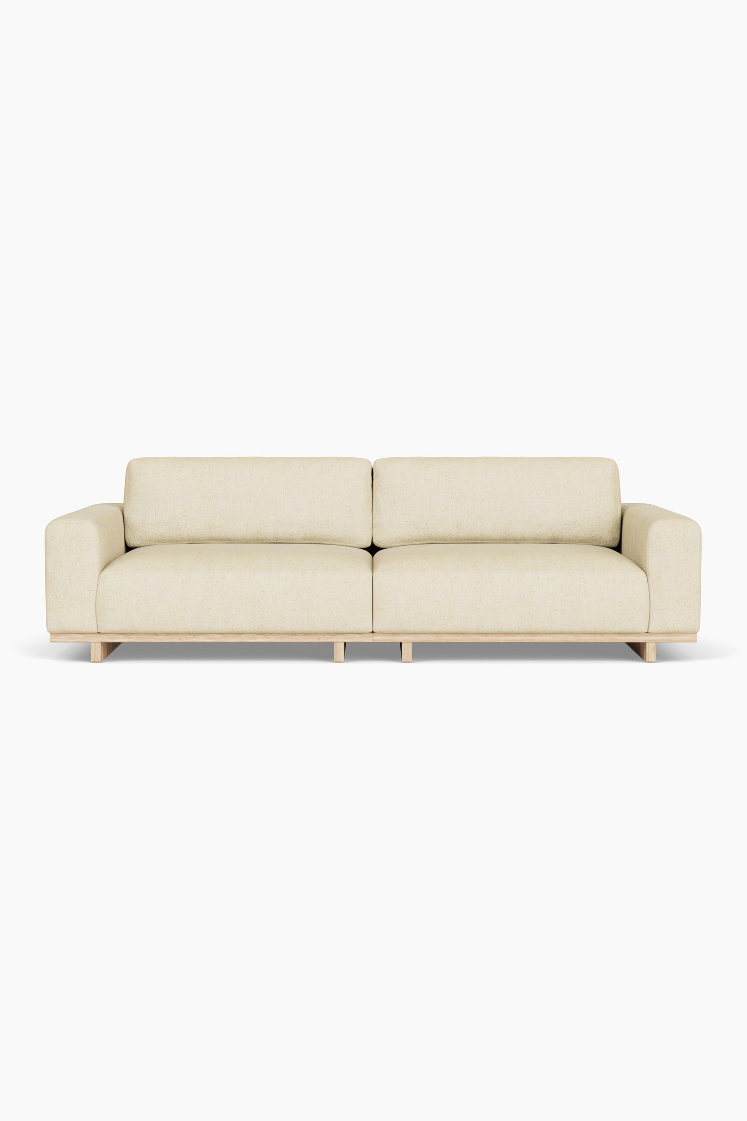 Ein flach geschnittenes modulares Sofa-Set aus cremefarbenem Strukturbstoff ist frontal ausgerichtet und besteht aus einem Zweisitzer-Sofa mit breiten Armlehnen sowie einem passenden rechteckigen Ottoman, der im Vordergrund platziert ist. Beide Elemente stehen auf hellen HolzblockfÃ¼Ãen, und ein passendes quadratisches Zierkissen liegt auf der rechten Seite des Sofas.