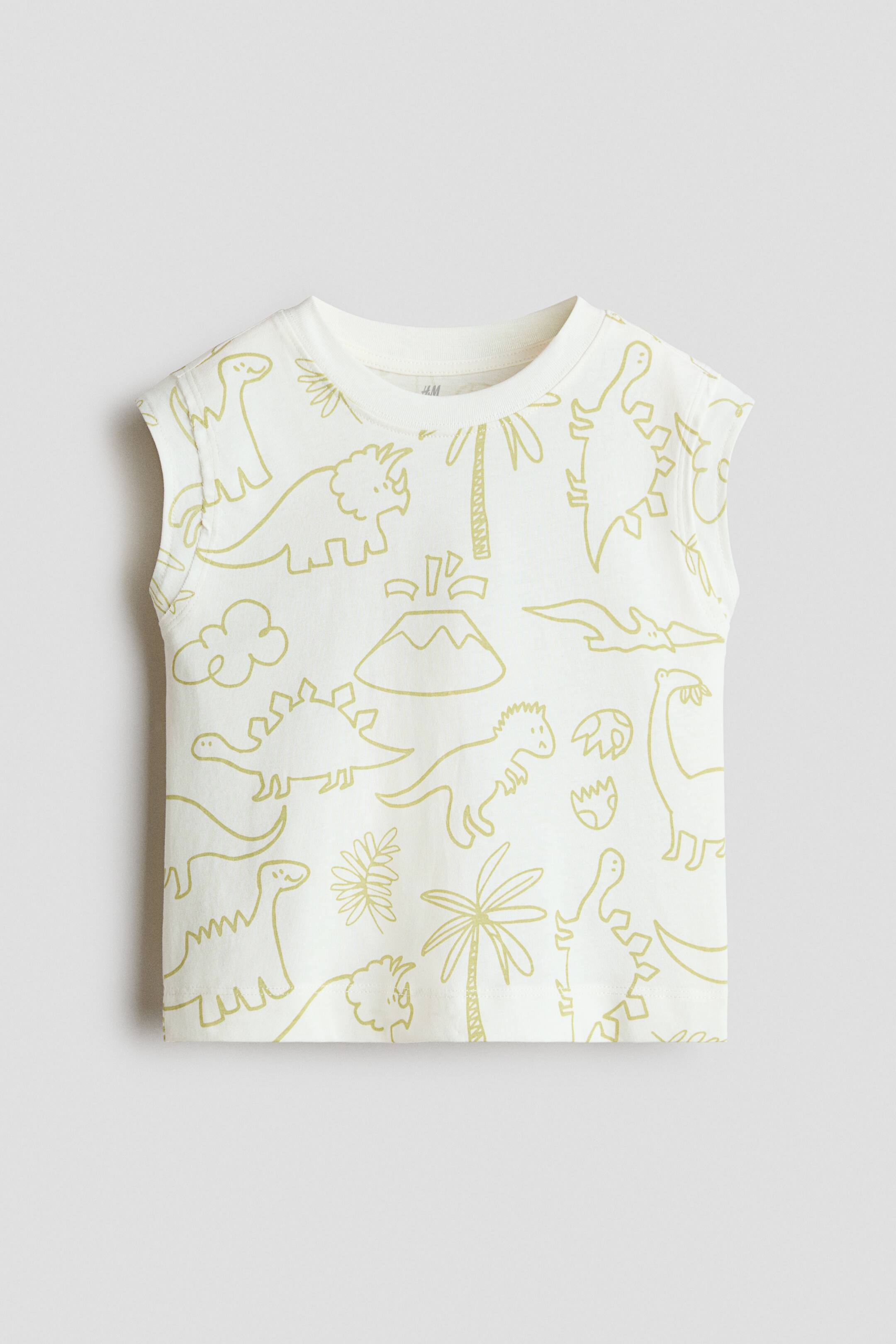View larger image: A sleeveless off-white T-shirt is shown from the front, featuring an all-over pattern of light-green line-art dinosaurs, palm trees, and a volcano. The shirt has a ribbed crew neck, wide shoulder straps, and a straight hem.