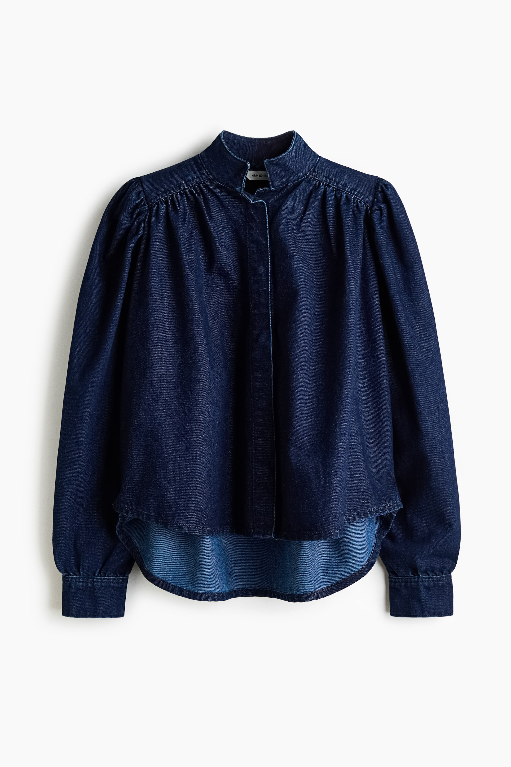 View larger image: A dark blue denim shirt is presenting FRONT, featuring a stand-up collar and long sleeves with gathered shoulders and buttoned cuffs. It is showcasing a concealed button-front placket and a rounded hem.