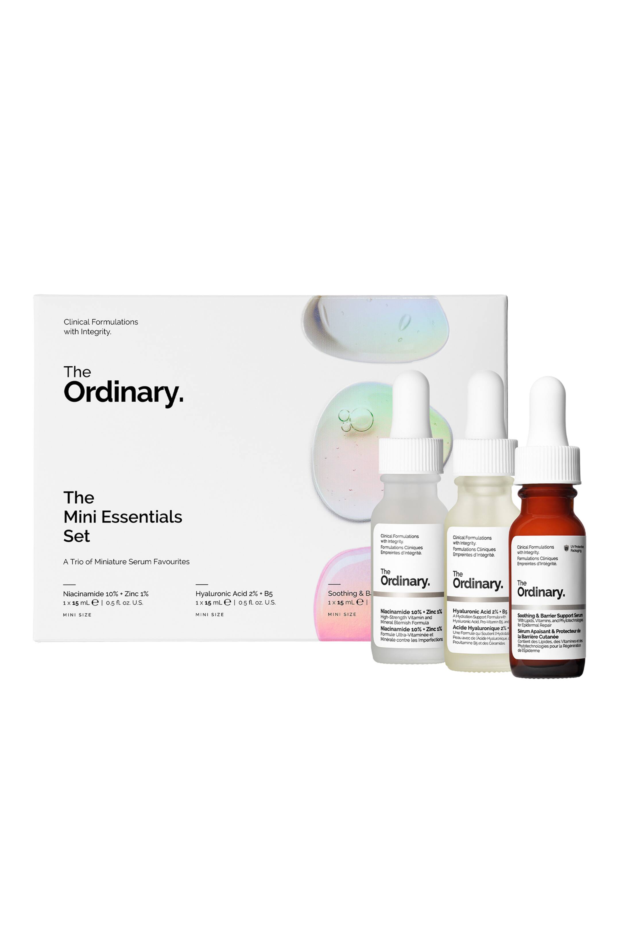 Visa större bild: Mini Essentials Set från The Ordinary visas som en vit rektangulär låda tillsammans med tre miniatyrflaskor med droppkork som står upprätt och vända framåt. Trion består av två flaskor i frostat glas och en bärnstensfärgad glasflaska, var och en med vit pipettkork och minimalistisk märkning.