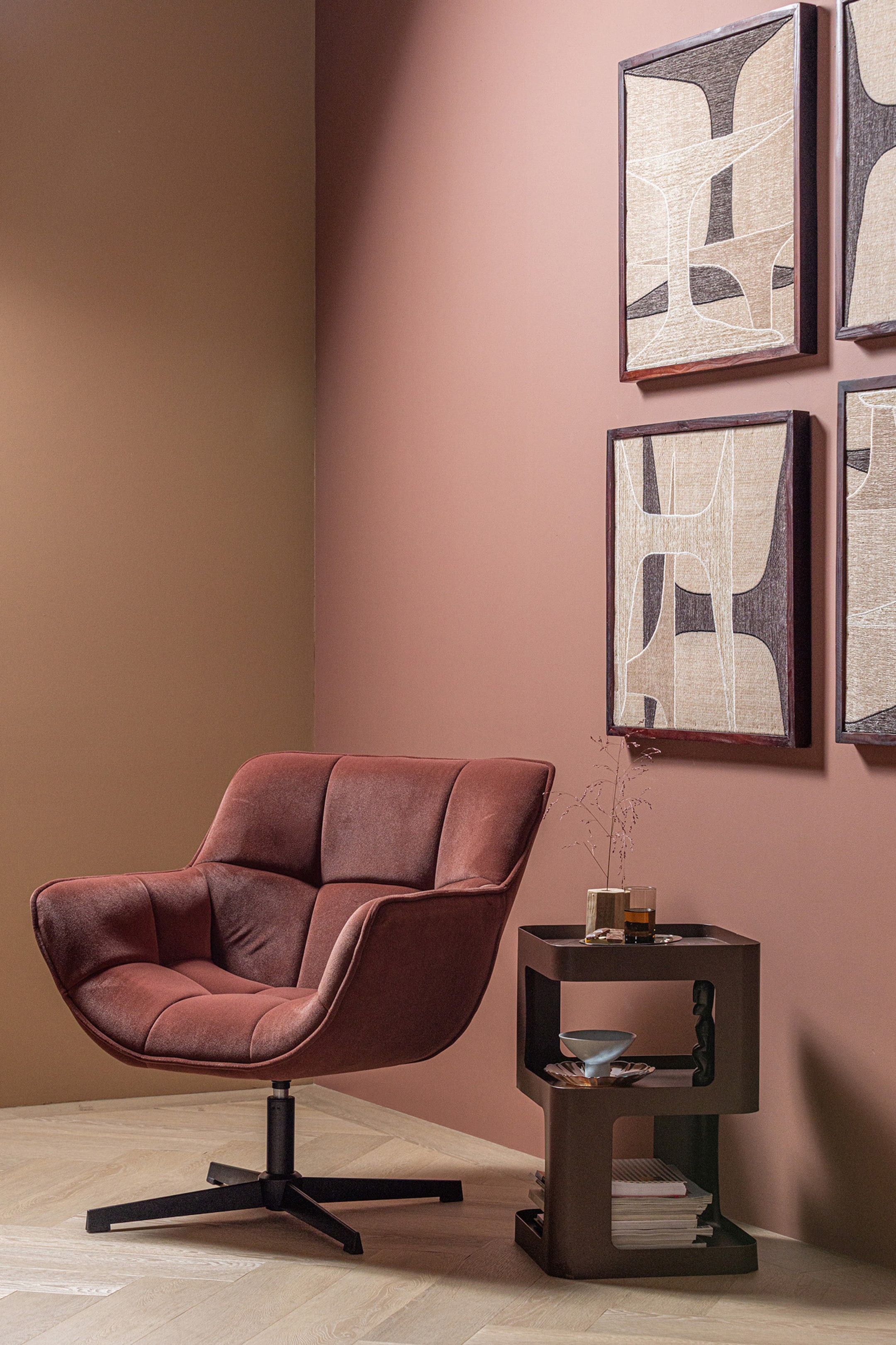 Agrandir l'image: Un fauteuil recouvert de tissu rose foncé présente des sections profondément matelassées sur son siège et son dossier. Il repose sur une base pivotante noire à quatre branches et est légèrement incliné vers la droite.