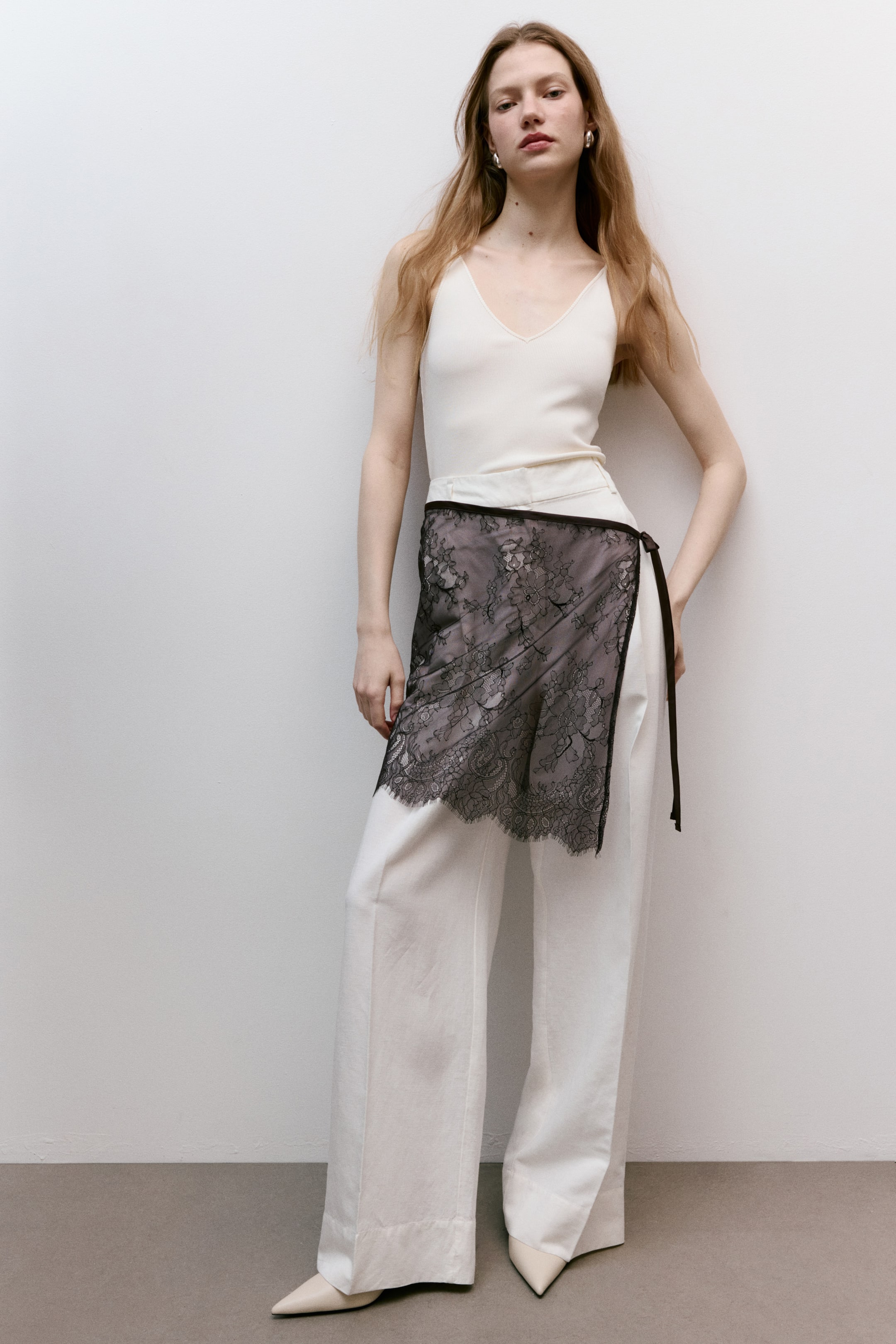 View larger image: Short hip scarf in black lace drapes across the front, showcasing a floral pattern and narrow ties securing it at one side.