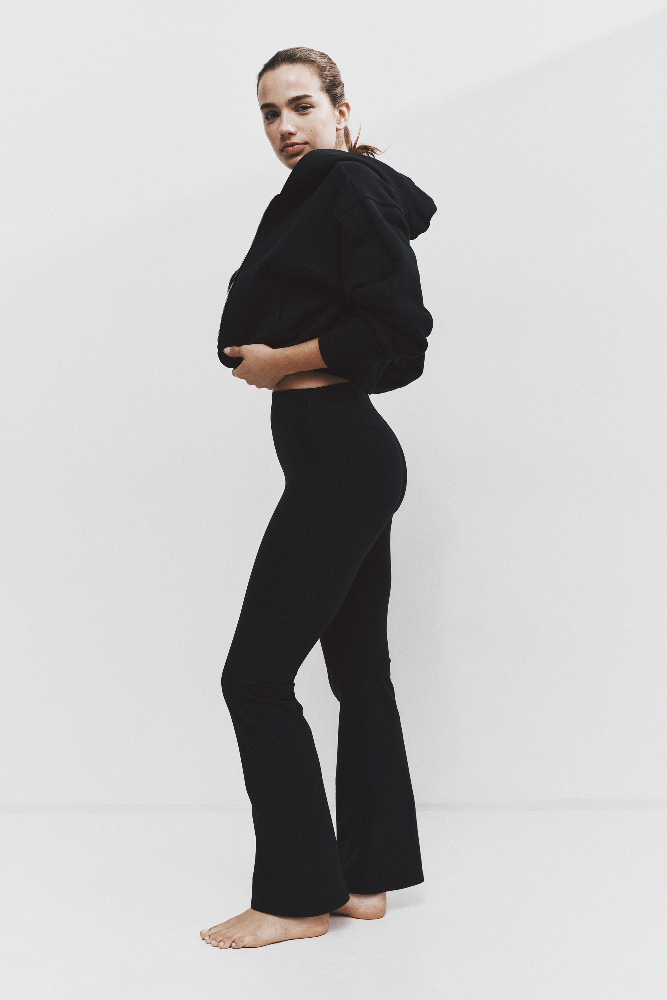 A pair of black wide-leg pants is displayed facing front, featuring a high, wide waistband and relaxed, straight legs.