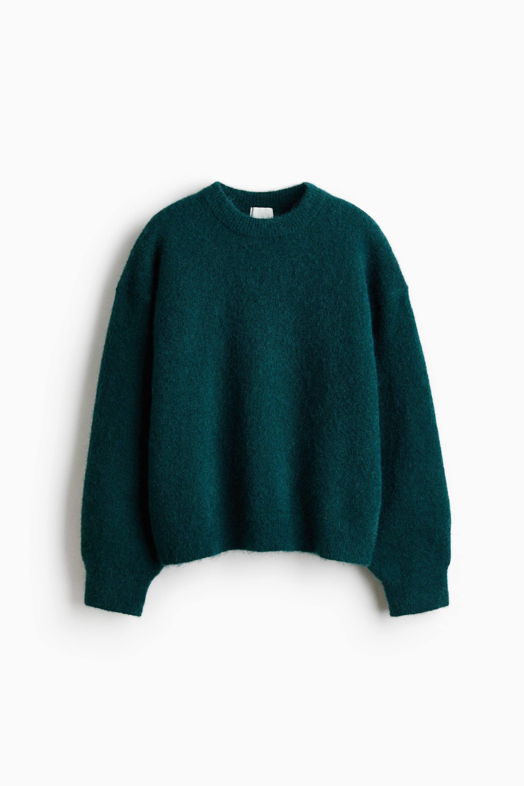 View larger image: A deep teal crew neck sweater is laid flat, showing its front view. It features a soft, brushed knit texture, long sleeves, and a relaxed fit with a straight hem.