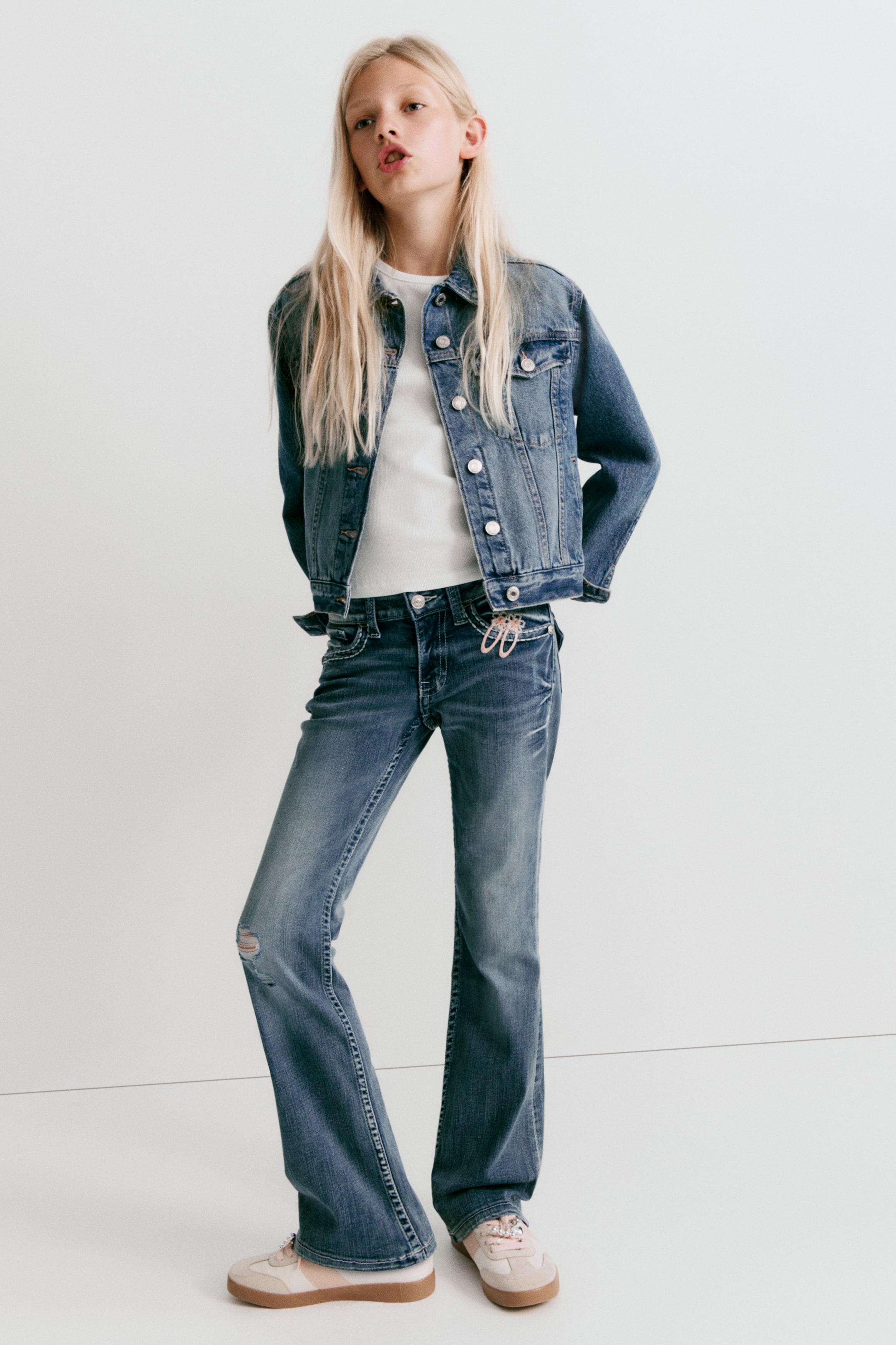 View larger image: The jeans feature a low-rise, skinny fit from the waist to the thigh, with a bootcut leg flaring from the knee to the hem. They are crafted from washed denim with worn-out details, and feature a zip fly with button fastening, front pockets, and a coin pocket.