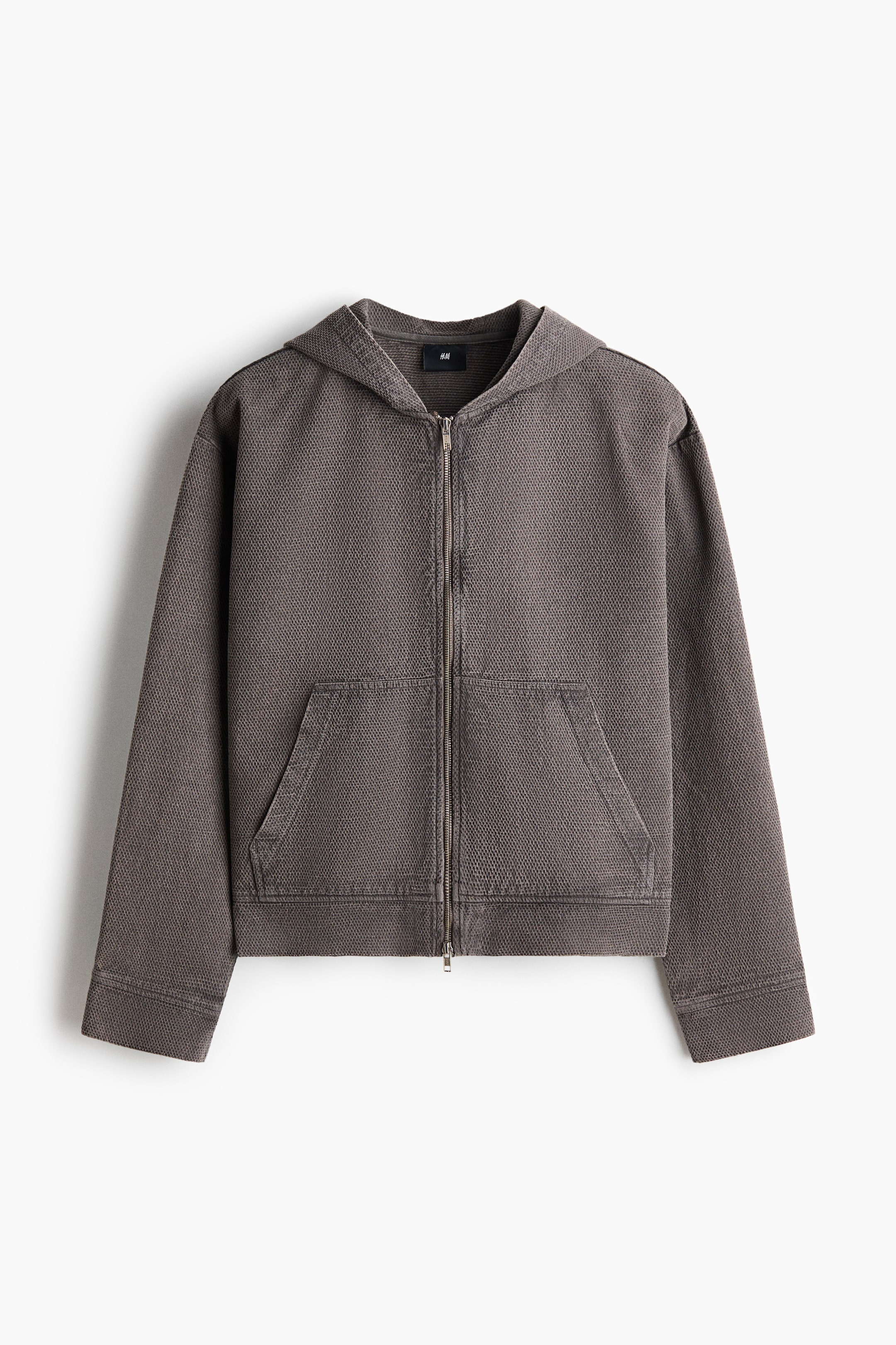 View larger image: A washed dark gray-brown textured zip-up hoodie is laid flat, facing forward. It features an attached hood, a full-length front zipper, and a kangaroo pocket, all crafted from a visible waffle knit fabric.