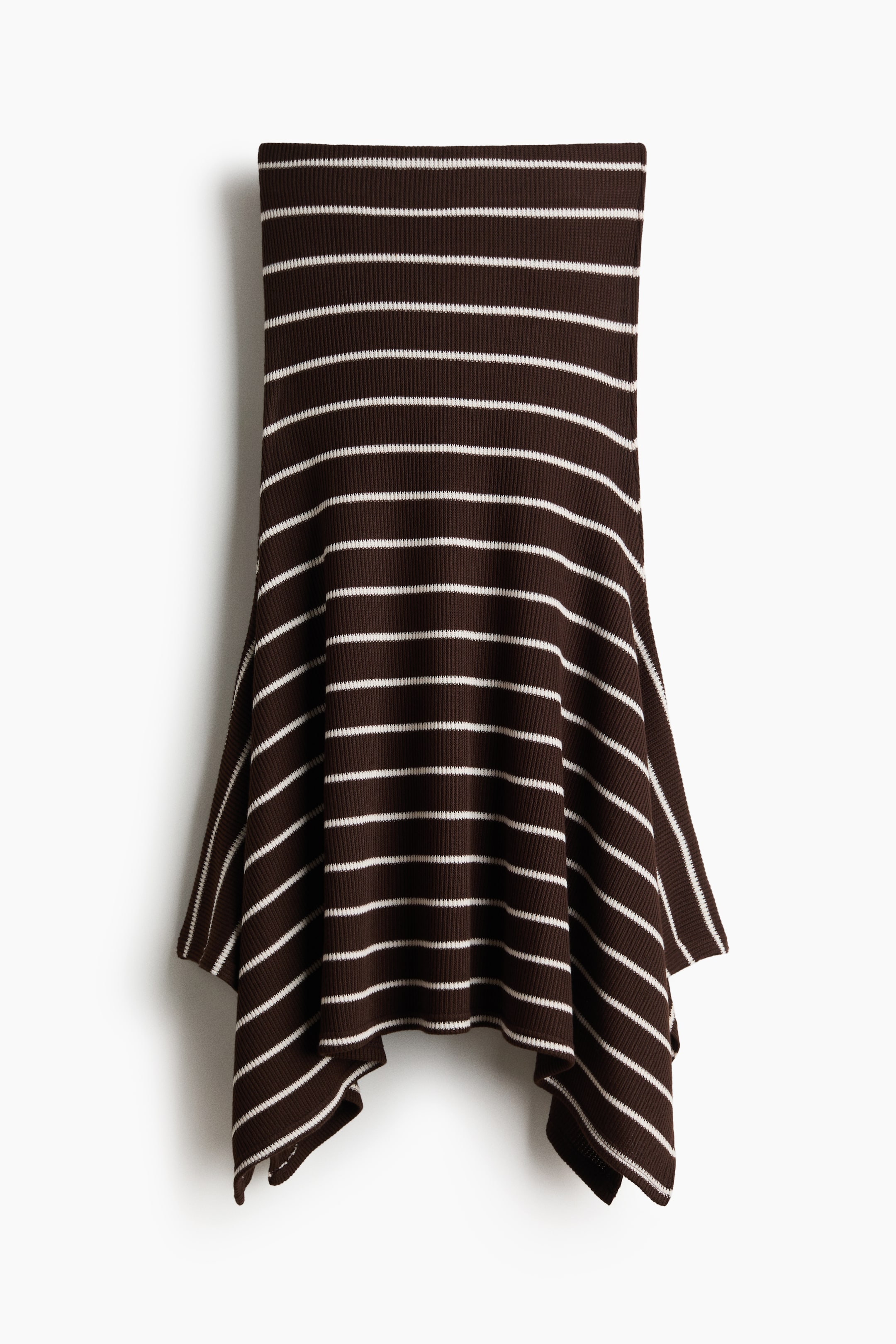 Büyük resmi görüntüle: "İnce beyaz yatay çizgili koyu kahverengi fitilli etek, genişleyen silueti ve asimetrik etek ucu ile düz bir şekilde sergileniyor."