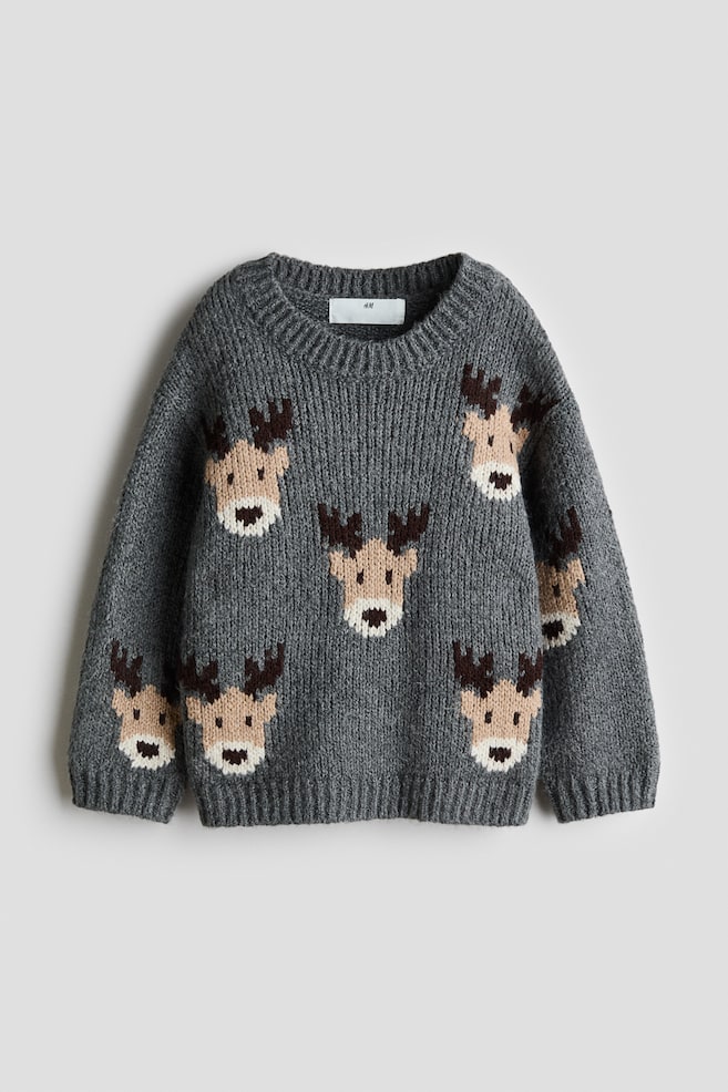 Ein grauer Jacquard-Strickpullover ist von vorne zu sehen und zeigt ein Ã¼ber den gesamten Rumpf und die Ãrmel verteiltes Muster aus Rentiergesichtern. Der Pullover ist mit einem runden Rippkragen, Ã¼berschnittenen Schultern sowie RippbÃ¼ndchen an den Ãrmeln und am Saum gestaltet. - 1