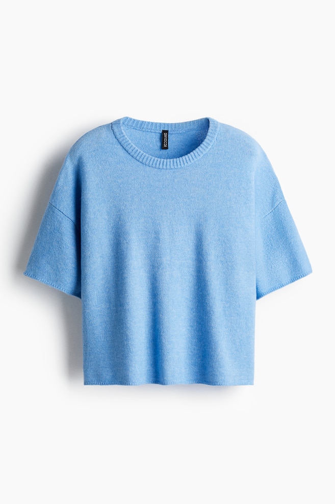 A light blue knit top is being displayed from the front. It is showing a ribbed crew neck, and wide, short sleeves are dropping from the shoulders. The top is presenting a relaxed fit, and its hem is appearing straight. - 1