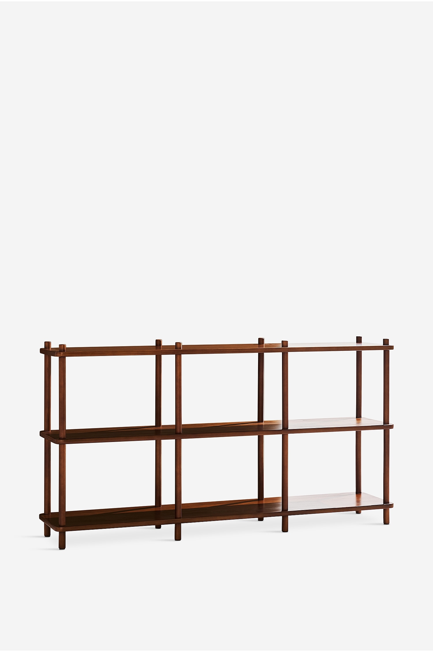 Ein dreistöckiges Holzregal steht in leichtem Winkel und verfügt über drei horizontale Ablageflächen, die von runden, vertikalen Holzpfosten getragen werden, welche leicht über das oberste Regal hinausragen. Das offene Konsolenelement zeigt eine warme, rötlich-braune Holzmaserung mit einem dreispaltigen modularen Design.