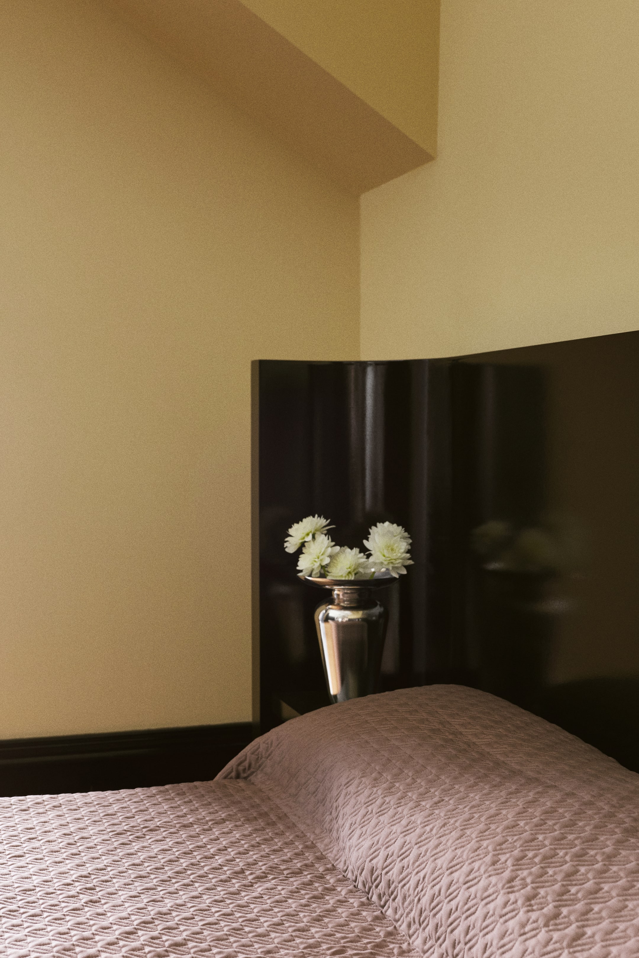Voir une image plus grande: Une courtepointe légèrement rembourrée, mauve, présentant un motif matelassé décoratif, est disposée sur un lit, mettant en valeur sa texture douce et son léger lustre. La courtepointe est drapée sur un oreiller, soulignant son tombé structuré et son tissage détaillé.