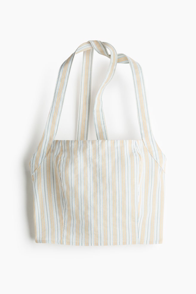 A striped halter crop top is shown from the front. It features vertical stripes in white, light blue and beige, a straight neckline, thin straps and subtle shaping seams on the front bodice. - 1