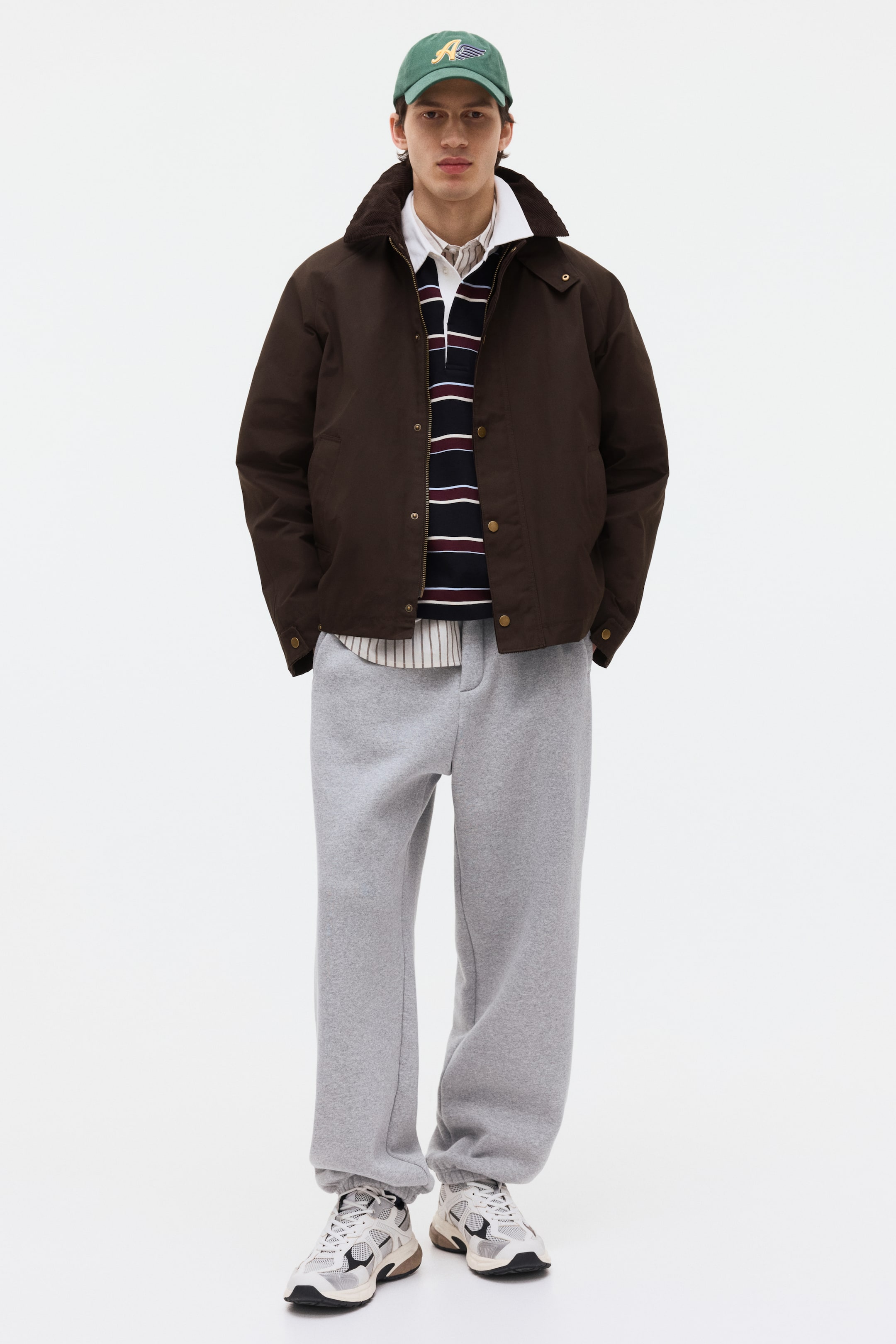 Ampliar la imagen: Pantalones de chándal grises en un material suave muestran un ajuste relajado con puños elásticos que se reúnen en los tobillos.