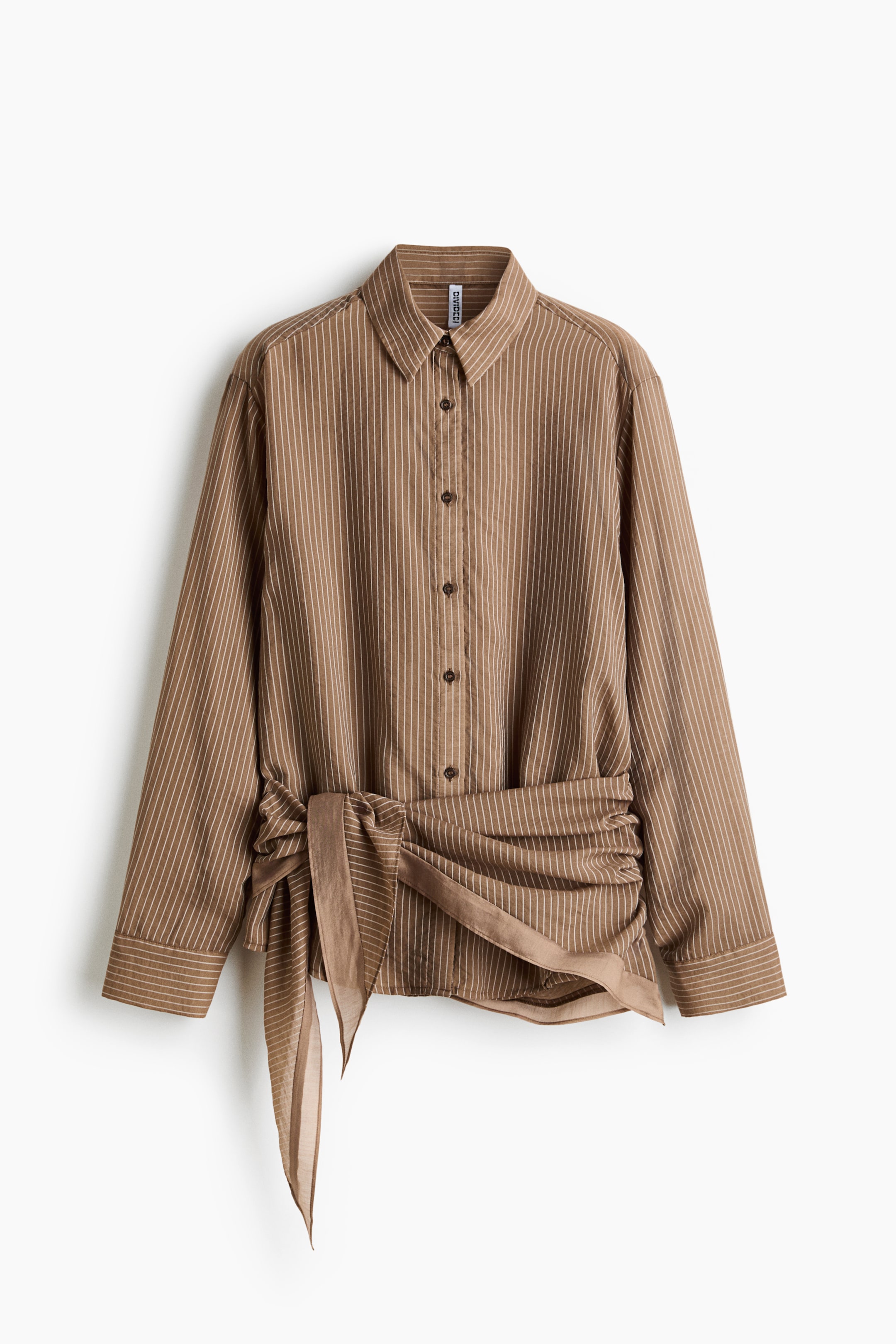View larger image: A brown and white striped button-down shirt is facing frontally, featuring a pointed collar and long sleeves with buttoned cuffs. An integrated tie detail is wrapping around the waist, creating front ruching, with its solid brown, slightly sheer ends knotted and draping.