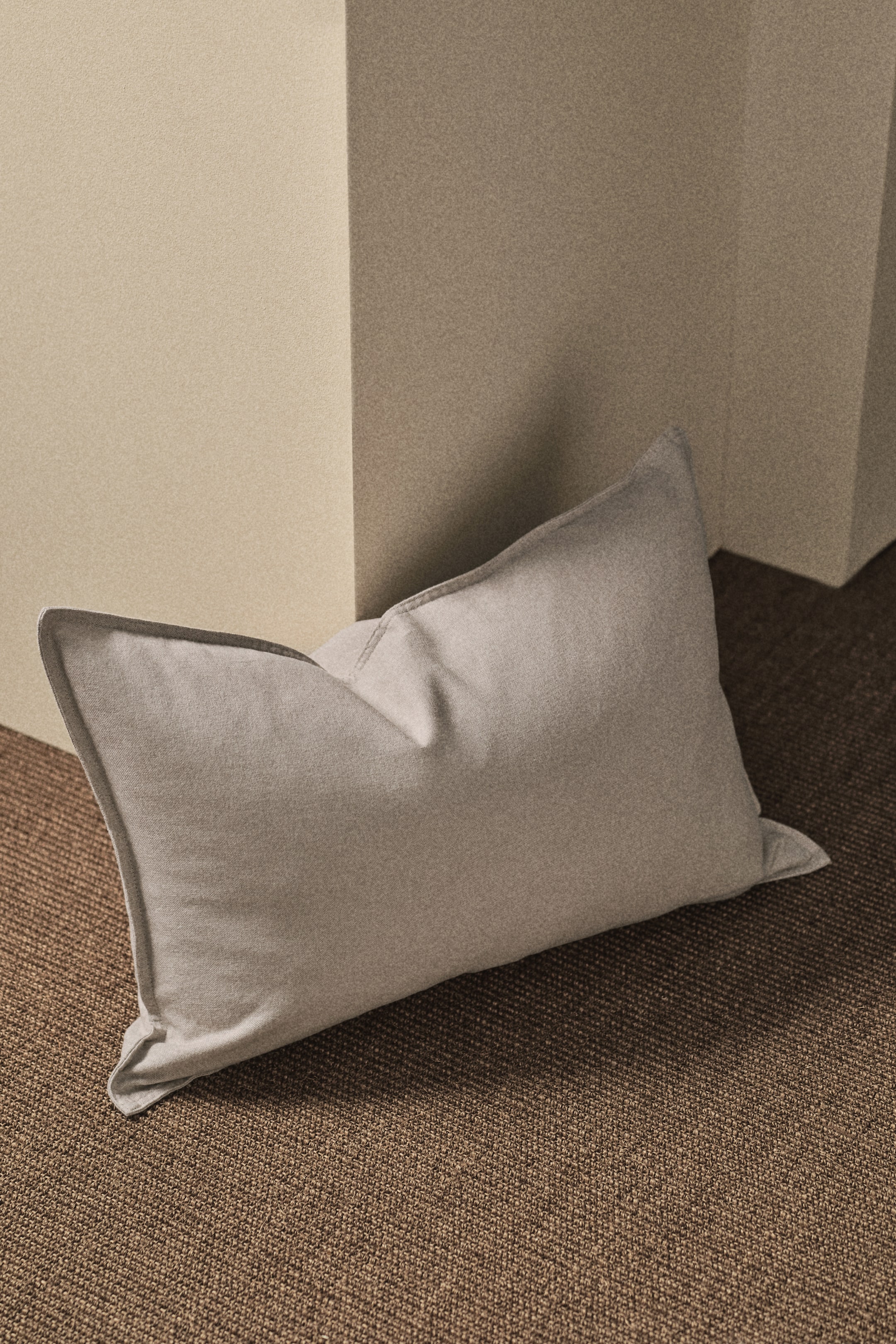 Agrandir l'image: Une housse de coussin intemporelle présente un tissage en lin et coton, avec des coutures le long de ses côtés et une fermeture éclair dissimulée à l'arrière.