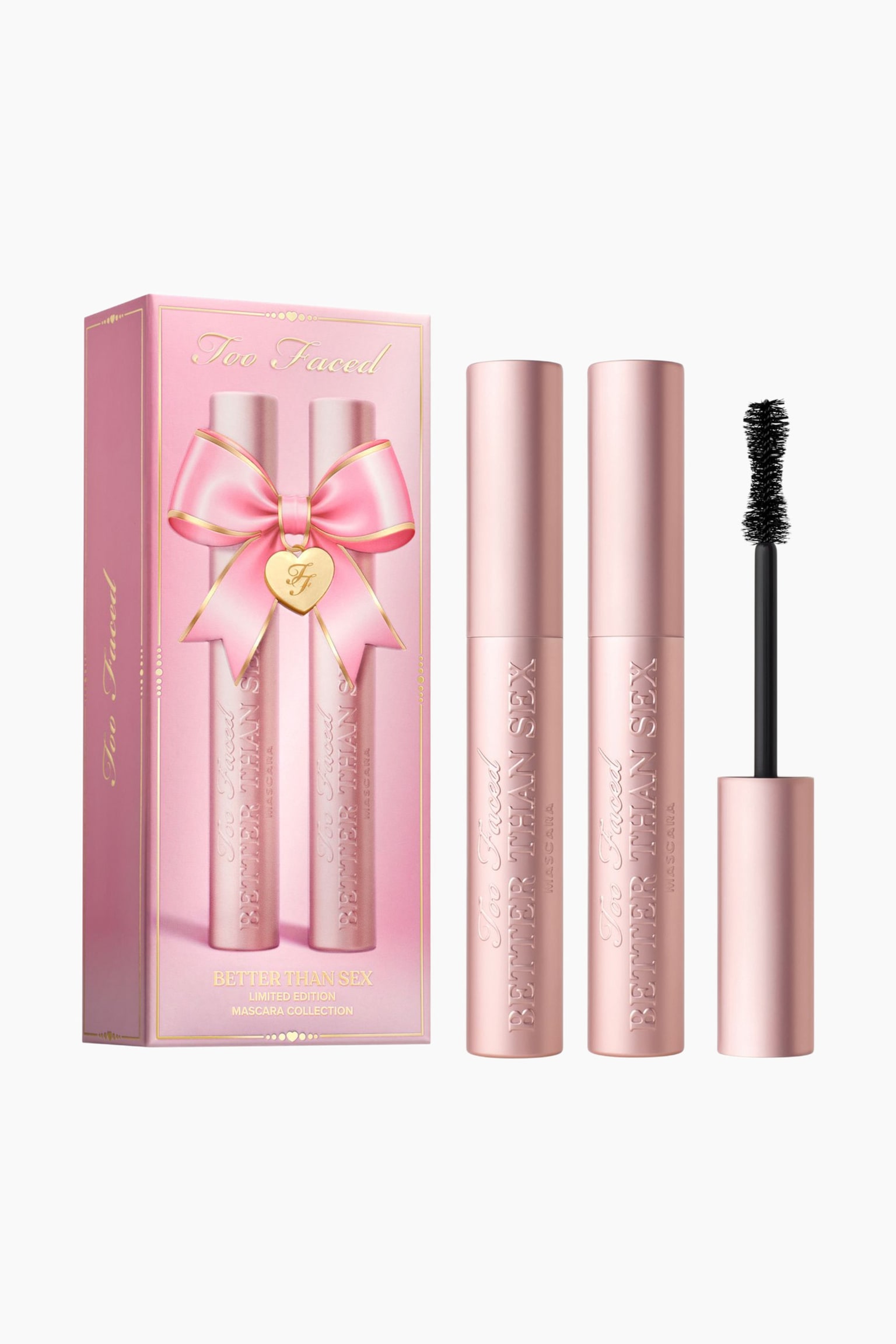 Too Faced -ripsasarjassa on vaaleanpunainen suorakulmainen laatikko, jota koristaa vaaleanpunainen rusettigrafiikka, ja sen vieressÃ¤ on kaksi metallinhohtoista vaaleanpunaista ripsivÃ¤rituubia sekÃ¤ irrotettu ripsivÃ¤riharja, jossa on tiimalasin muotoinen musta harjaosa. - 1