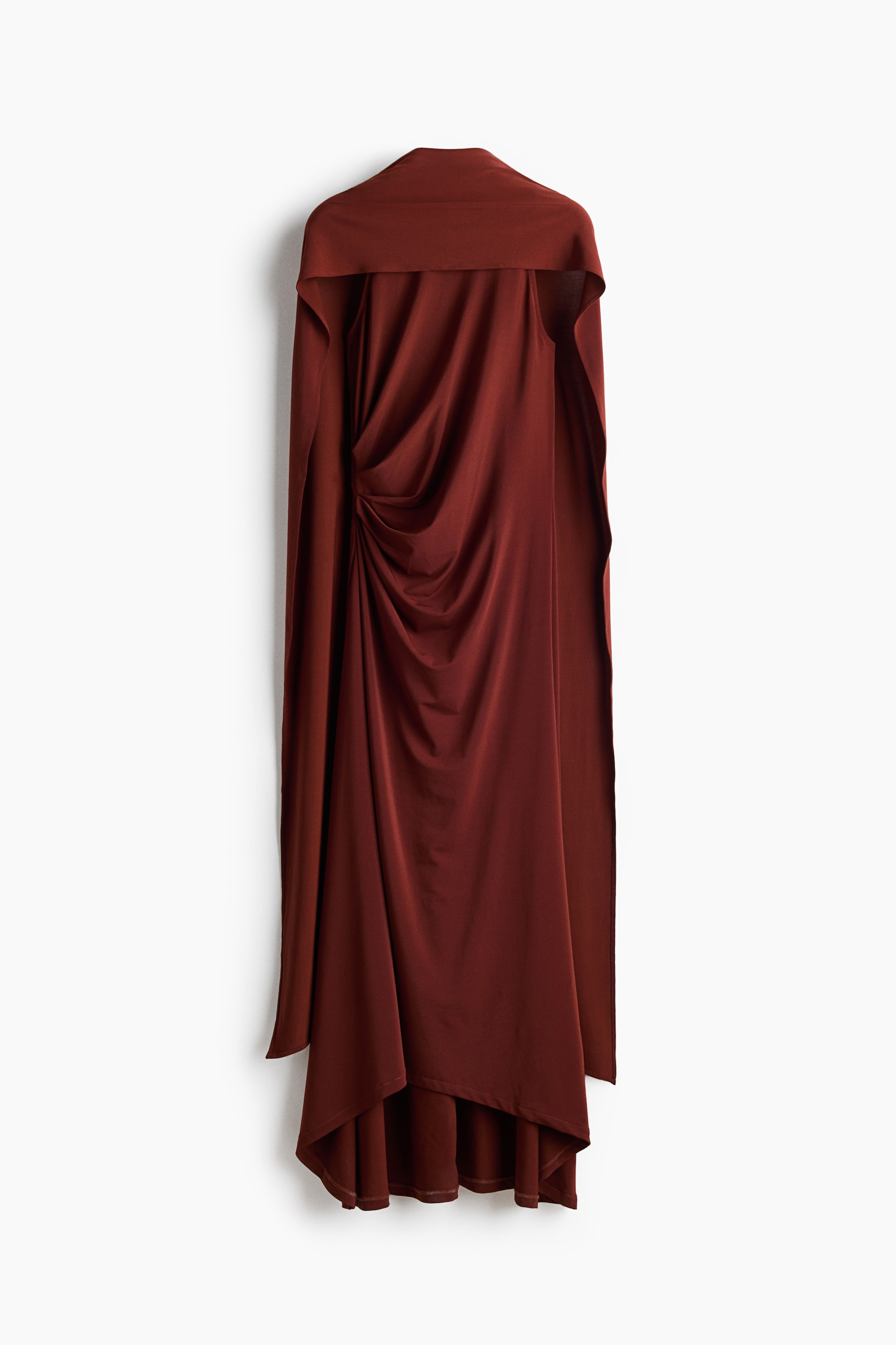 View larger image: A deep reddish-brown draped dress is showcased front-facing, featuring a wide, flowing collar extending over the shoulders. The left side is ruched, creating vertical folds, and the asymmetrical hemline drapes longer on the left.