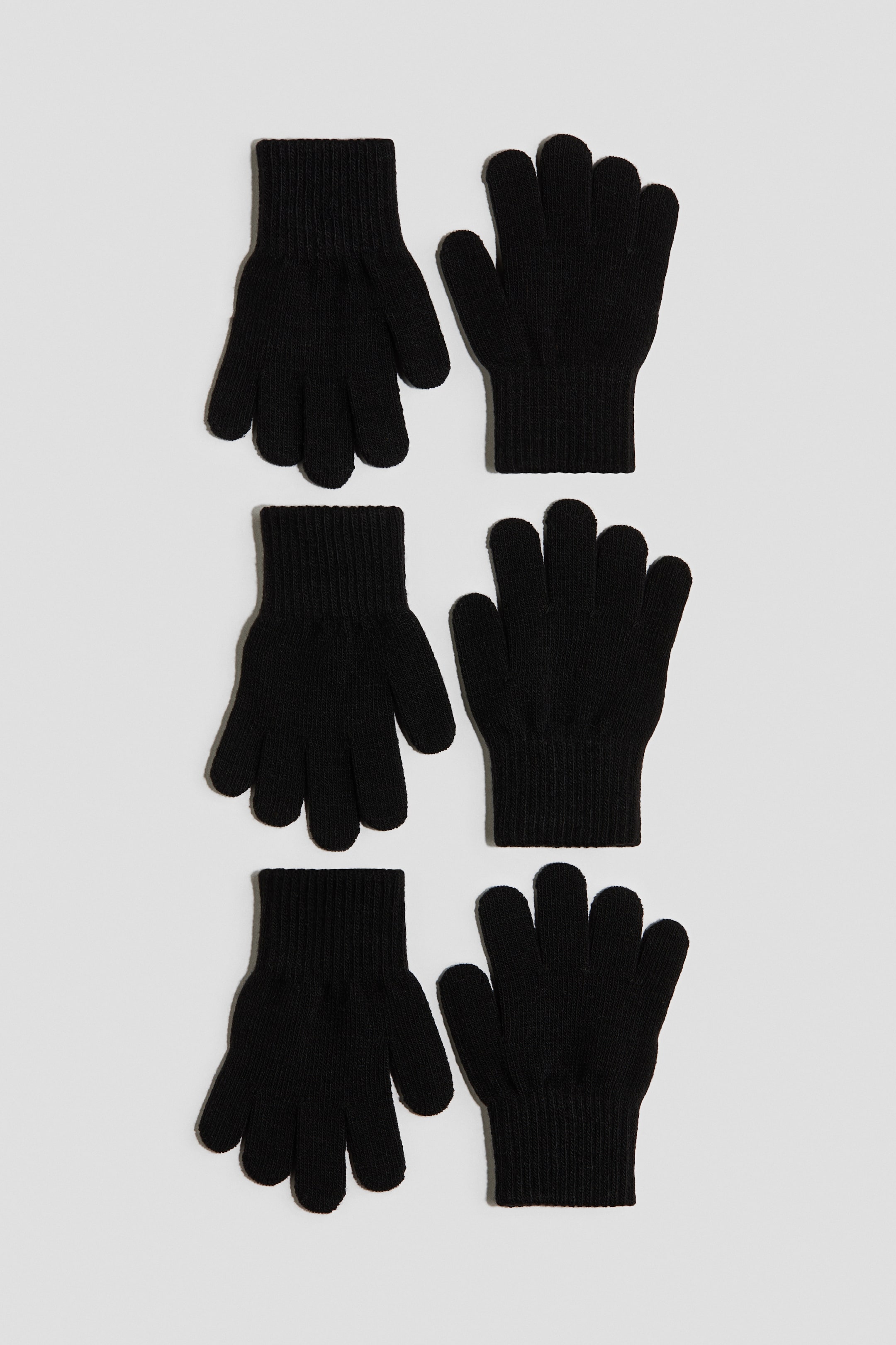 View larger image: Black gloves are showcased, boasting a soft, fine knit texture and ribbed cuffs.