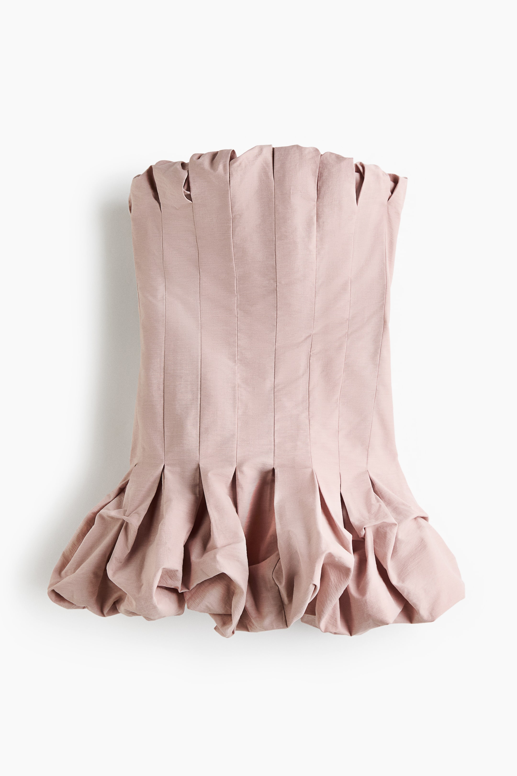 Grösseres Bild ansehen: Das blush-rosa, trägerlose Oberteil präsentiert eine strukturierte, plissierte obere Kante und vertikale Falten entlang der Vorderseite. Ein voluminöser, gerüschter Schößchen-Saum bildet am unteren Rand eine markante Blasen-Silhouette.