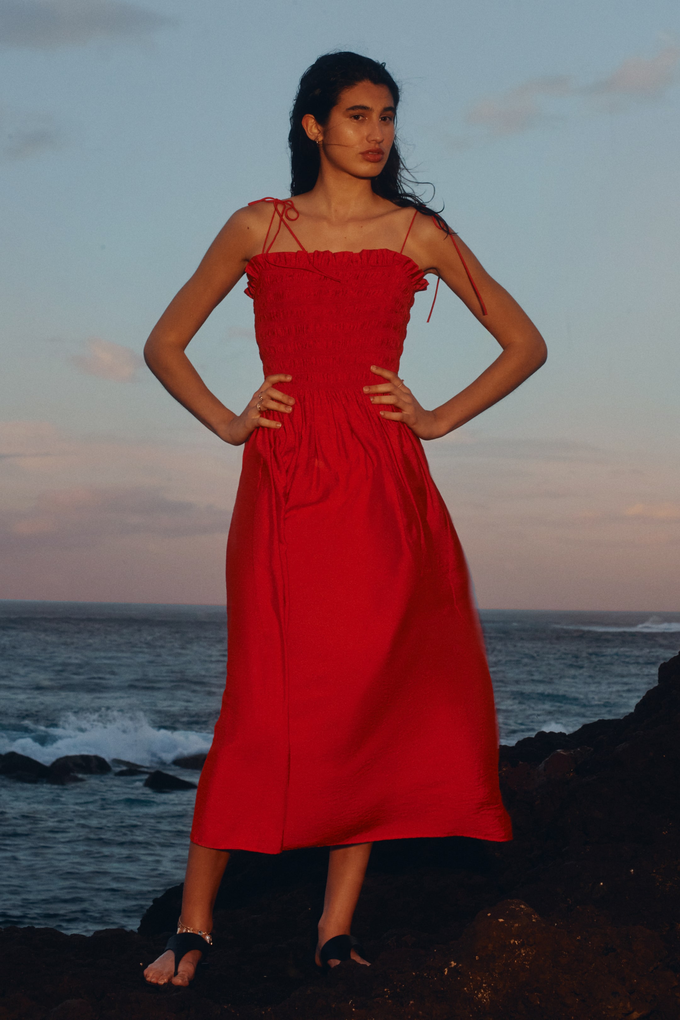 View larger image: A red midi dress showcasing a shirred bodice with delicate tie-shoulder straps and a graceful A-line skirt.