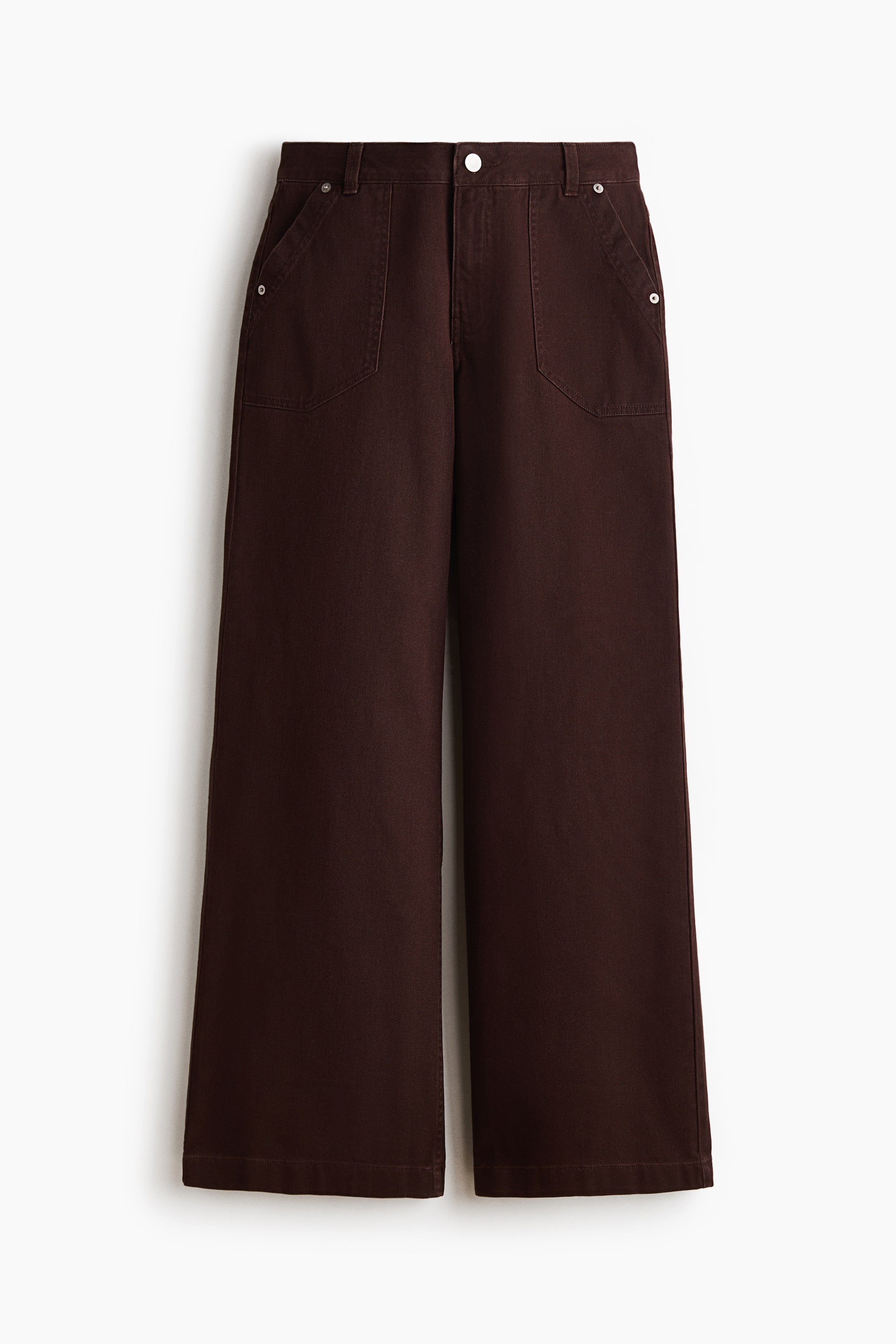 View larger image: Dark brown cotton twill trousers are showcased from the front. They feature a high waist with a zip fly and a noticeable silver-toned button, exhibiting wide legs and large patch side pockets accented by small silver-toned rivets.
