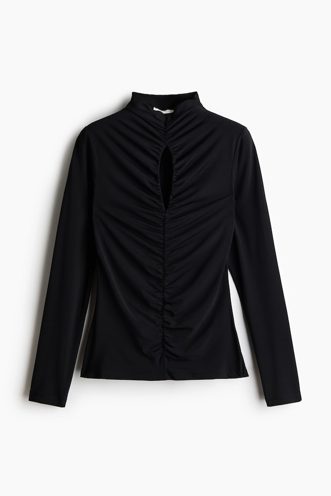 A black long-sleeve top is shown from the front, featuring a high mock neck and a vertical keyhole cut-out at the chest. Prominent vertical ruching runs down the centre front of the bodice, creating a gathered texture across the fabric. - 1