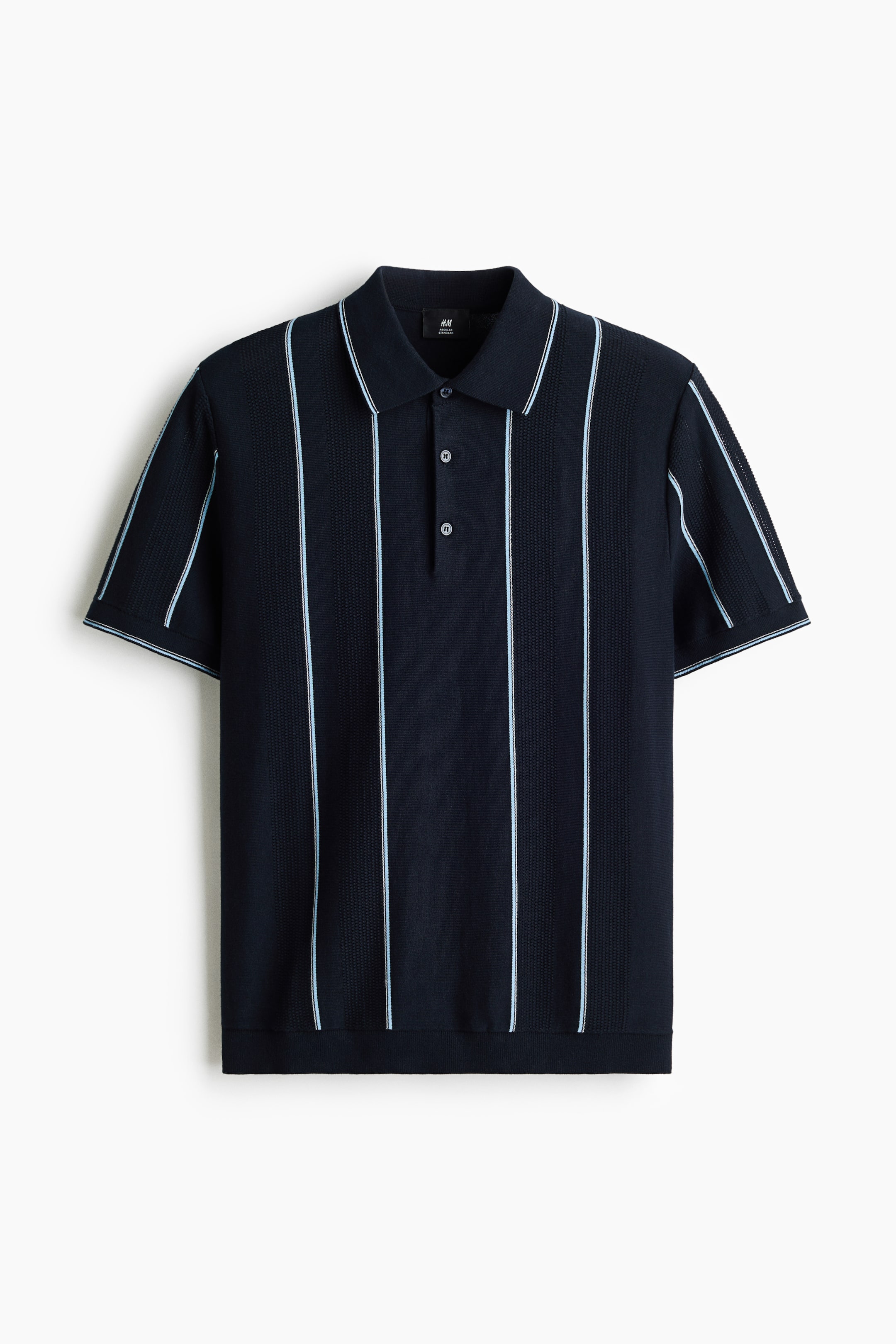 Ampliar la imagen: Una camisa polo de punto azul marino se presenta de frente, con llamativas rayas verticales en azul claro y blanco. Está diseñada con un cuello clásico, una tapeta de tres botones y mangas cortas y dobladillo acanalados.