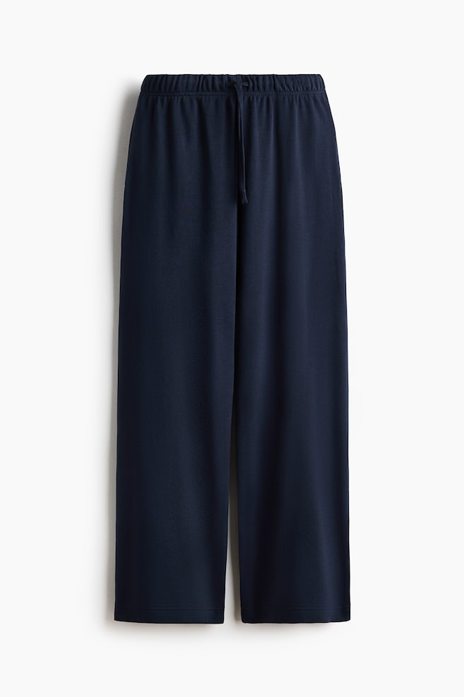 Dark blue joggers are shown in a front view, featuring an elasticated waistband with a drawstring fastening. The joggers are crafted with straight legs in a lightweight sweatshirt fabric. - 1